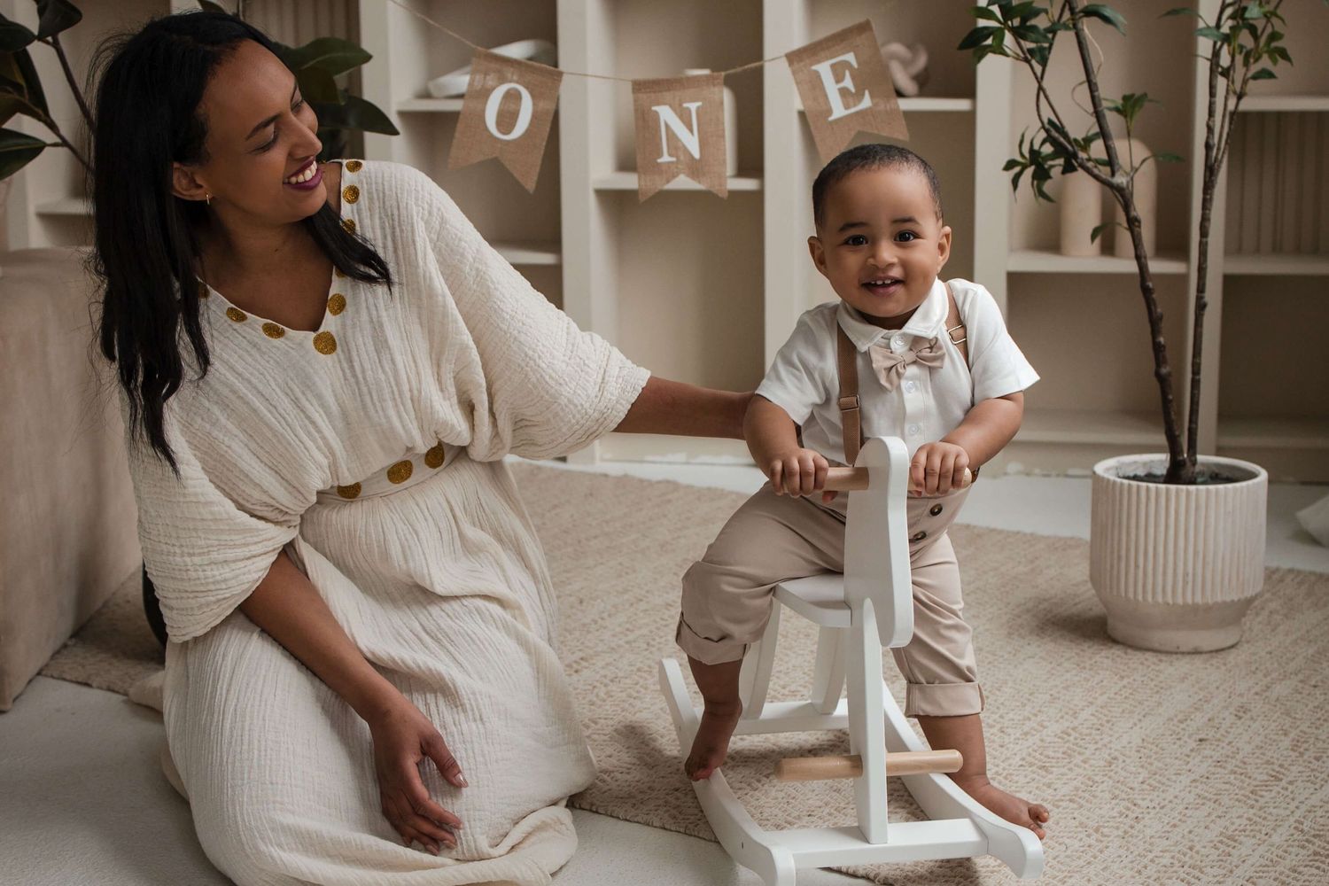 Mother and one-year-old sharing smiles during a cake smash session at Mint Room Studios in Toronto with timeless neutral decor.