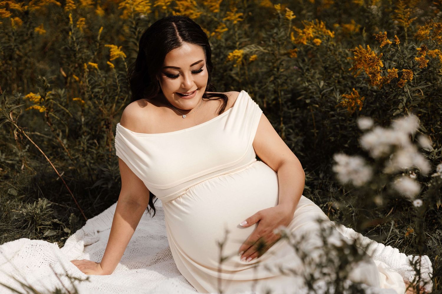 Expectant mother embracing her growing baby bump during an outdoor maternity photography session at Evergreen Brick Works in Toronto.