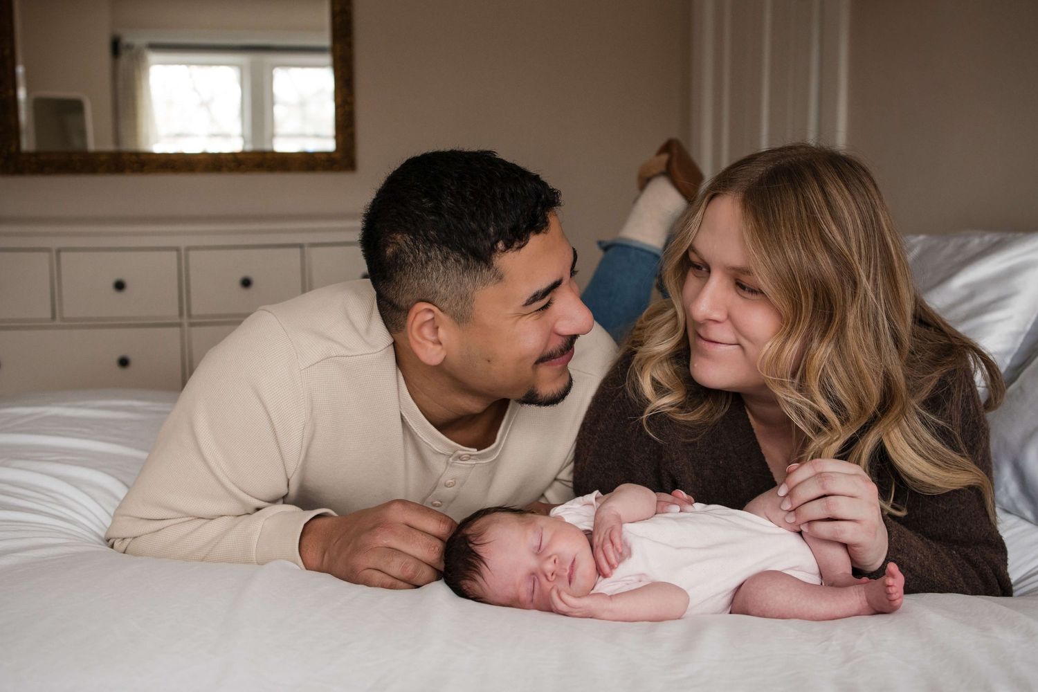 New parents sharing a loving moment with their newborn during a lifestyle newborn session in Toronto.