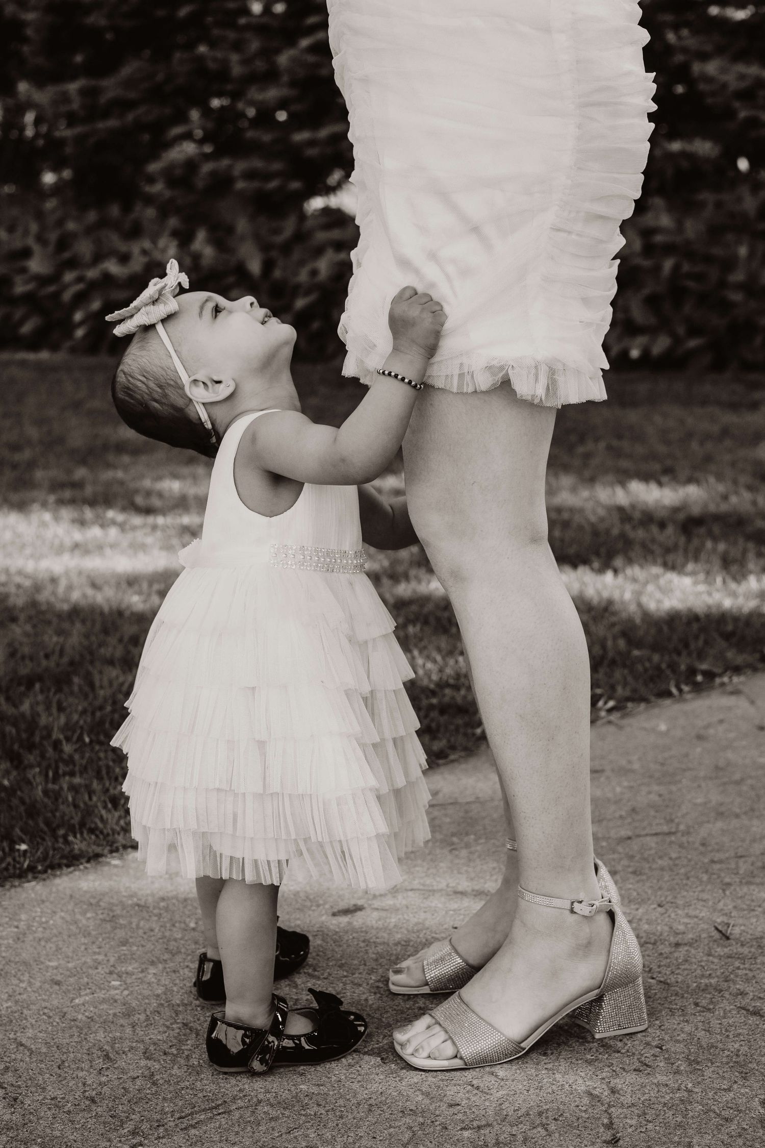 Little girl looking up at her mother during an outdoor family session in Toronto, capturing a timeless connection and love.