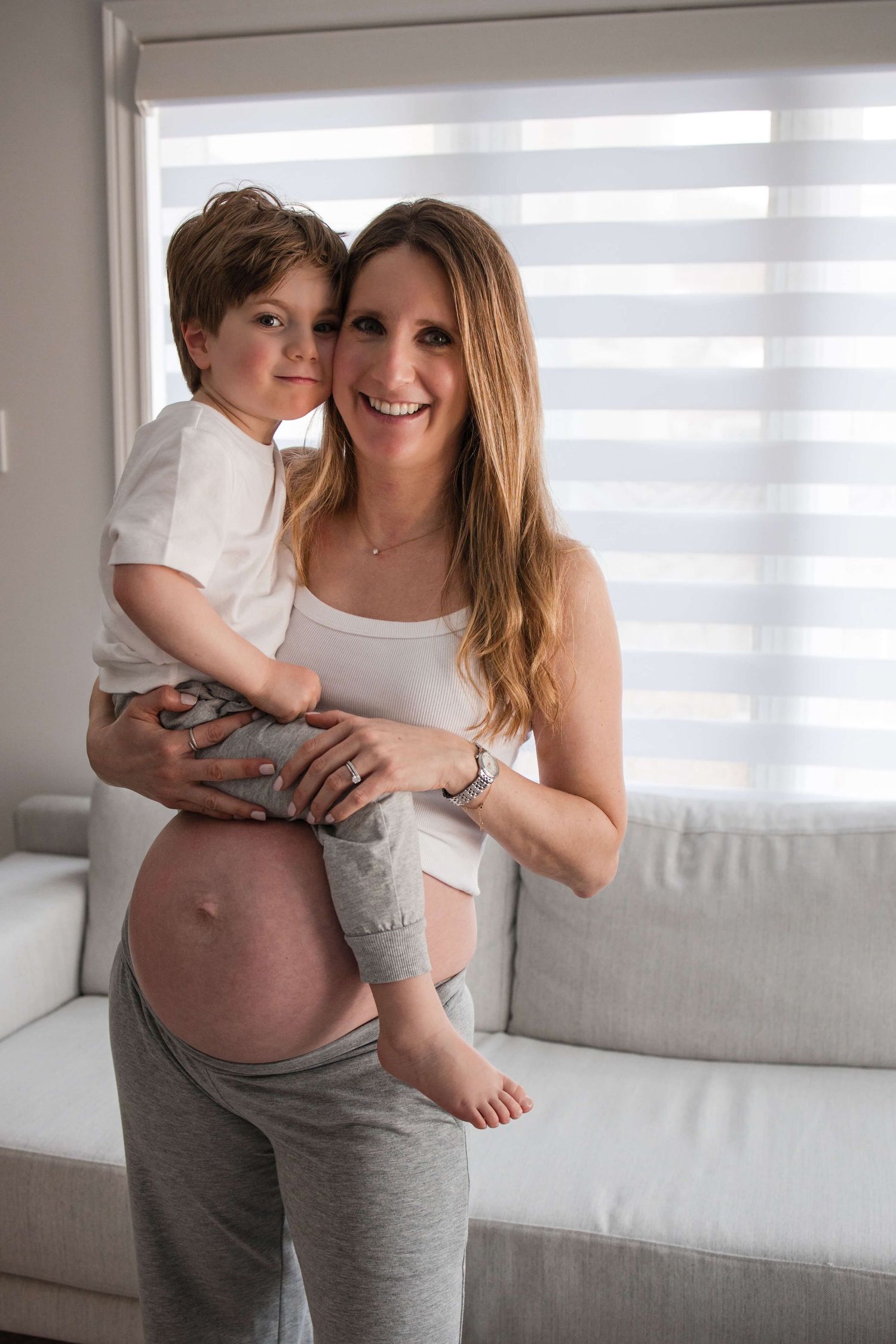 Expectant mother holding her child during an in-home maternity photography session in Toronto, celebrating motherhood and family.