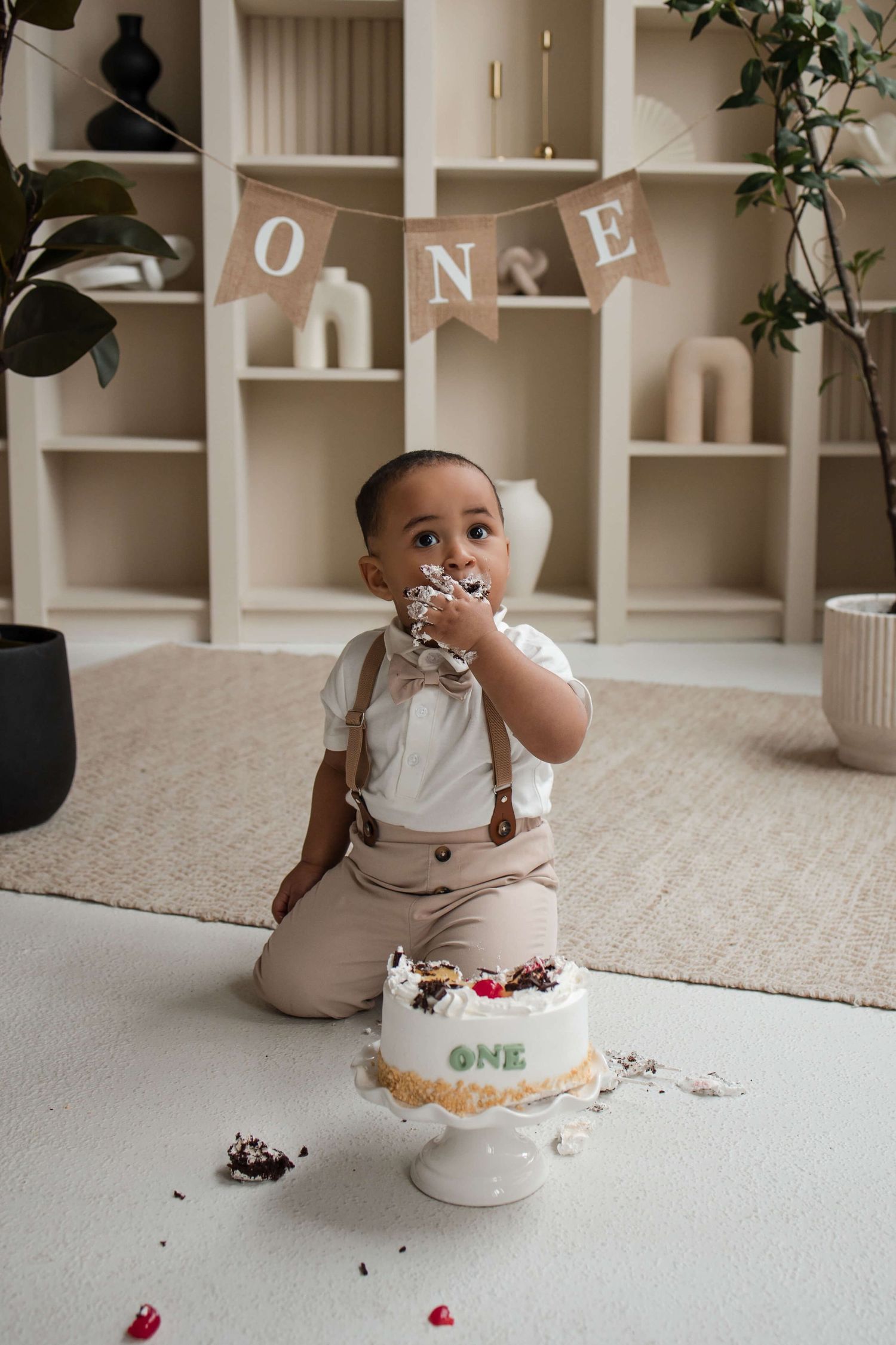 One-year-old enjoying a cake smash session at Mint Room Studios in Toronto with a simple neutral setup, timeless decor, and natural style.