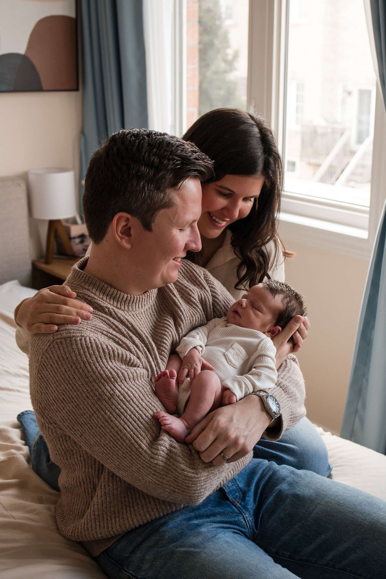 New parents admiring their newborn during a natural lifestyle newborn photography session in Toronto.