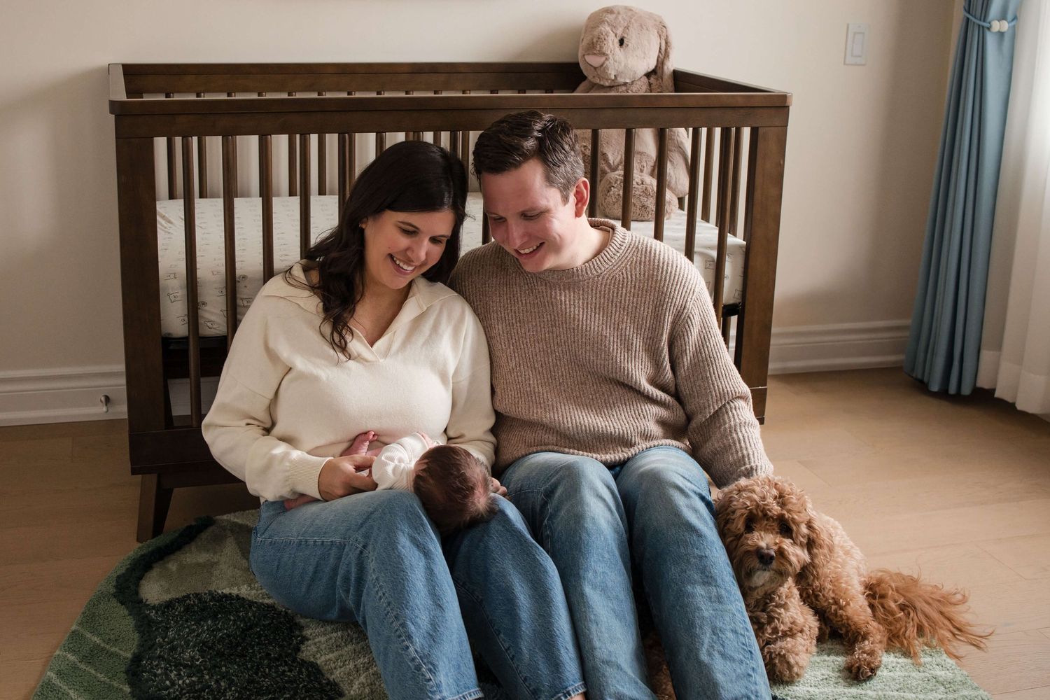New parents bonding with their newborn in the nursery during a lifestyle newborn session in Toronto.