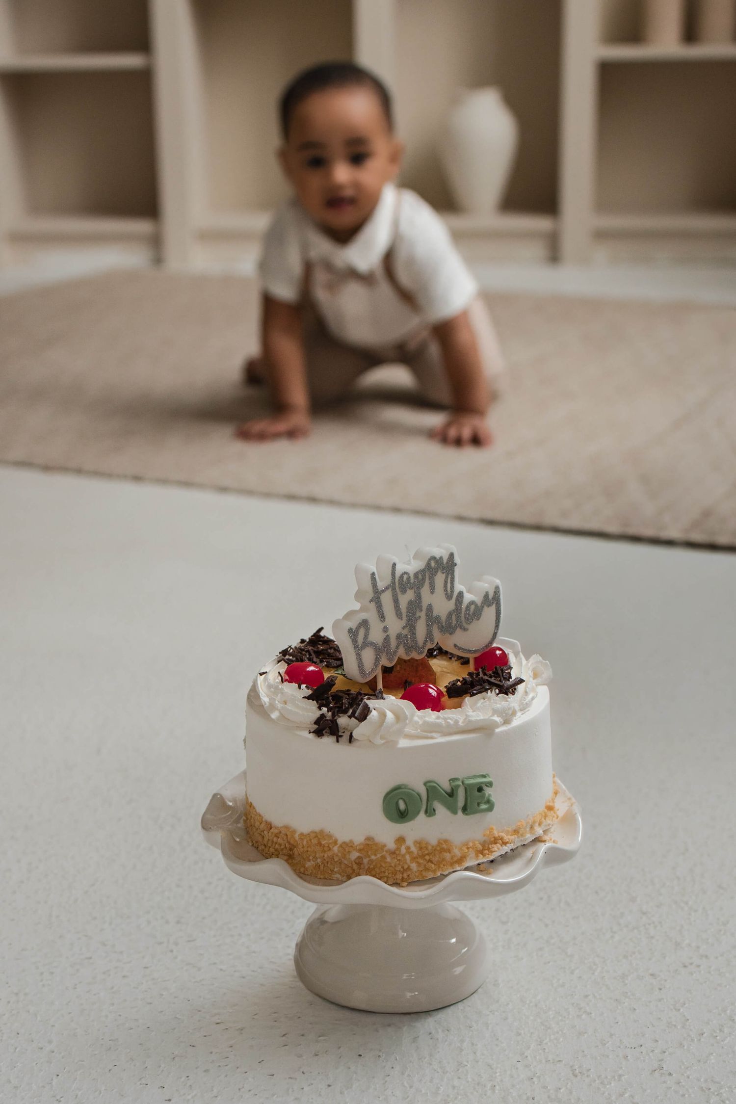 One-year-old enjoying a cake smash session at Mint Room Studios in Toronto with a simple neutral setup, timeless decor, and natural style.