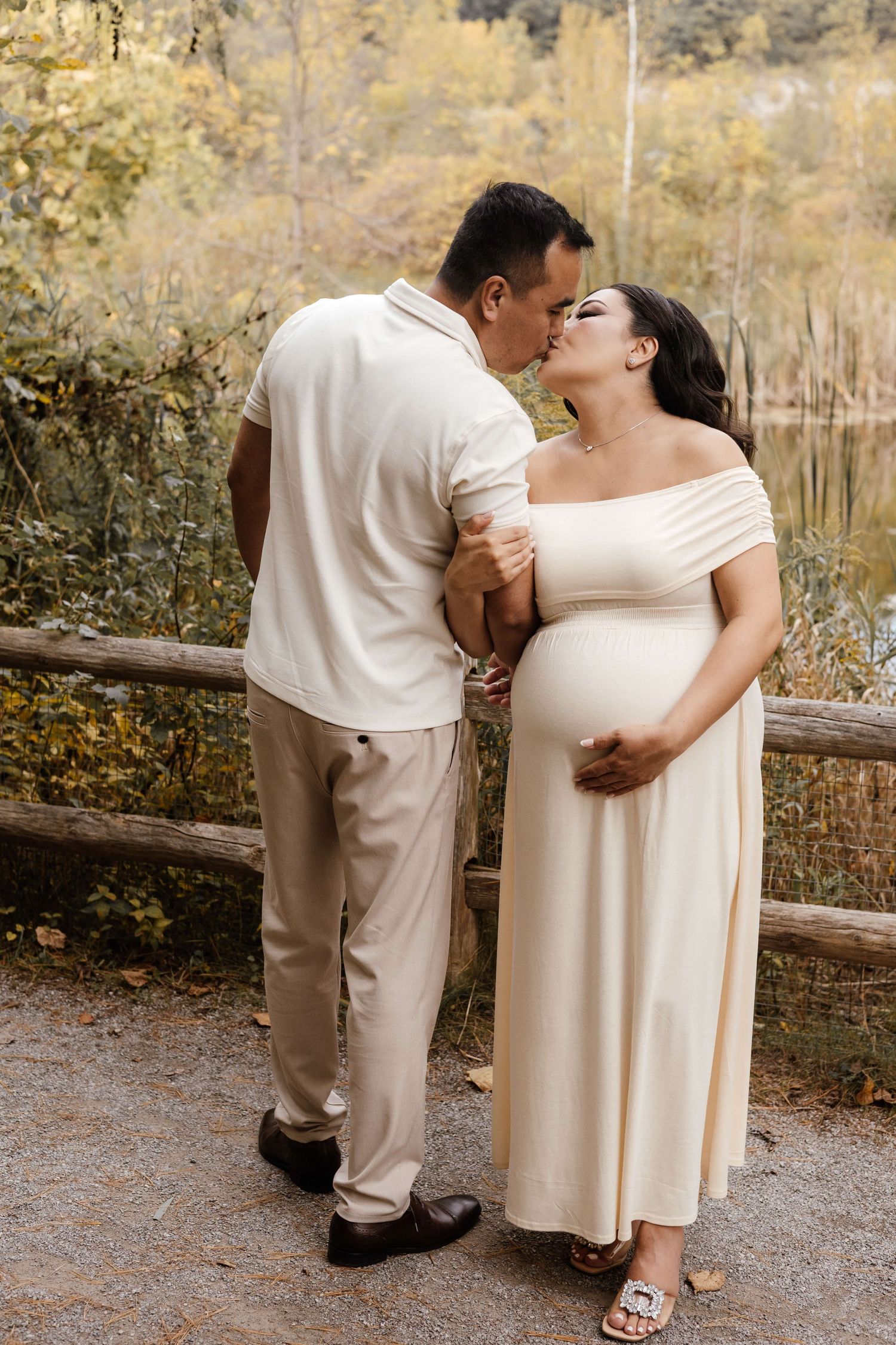 Expectant parents sharing a joyful moment at Evergreen Brick Works during an outdoor maternity photography session in Toronto.