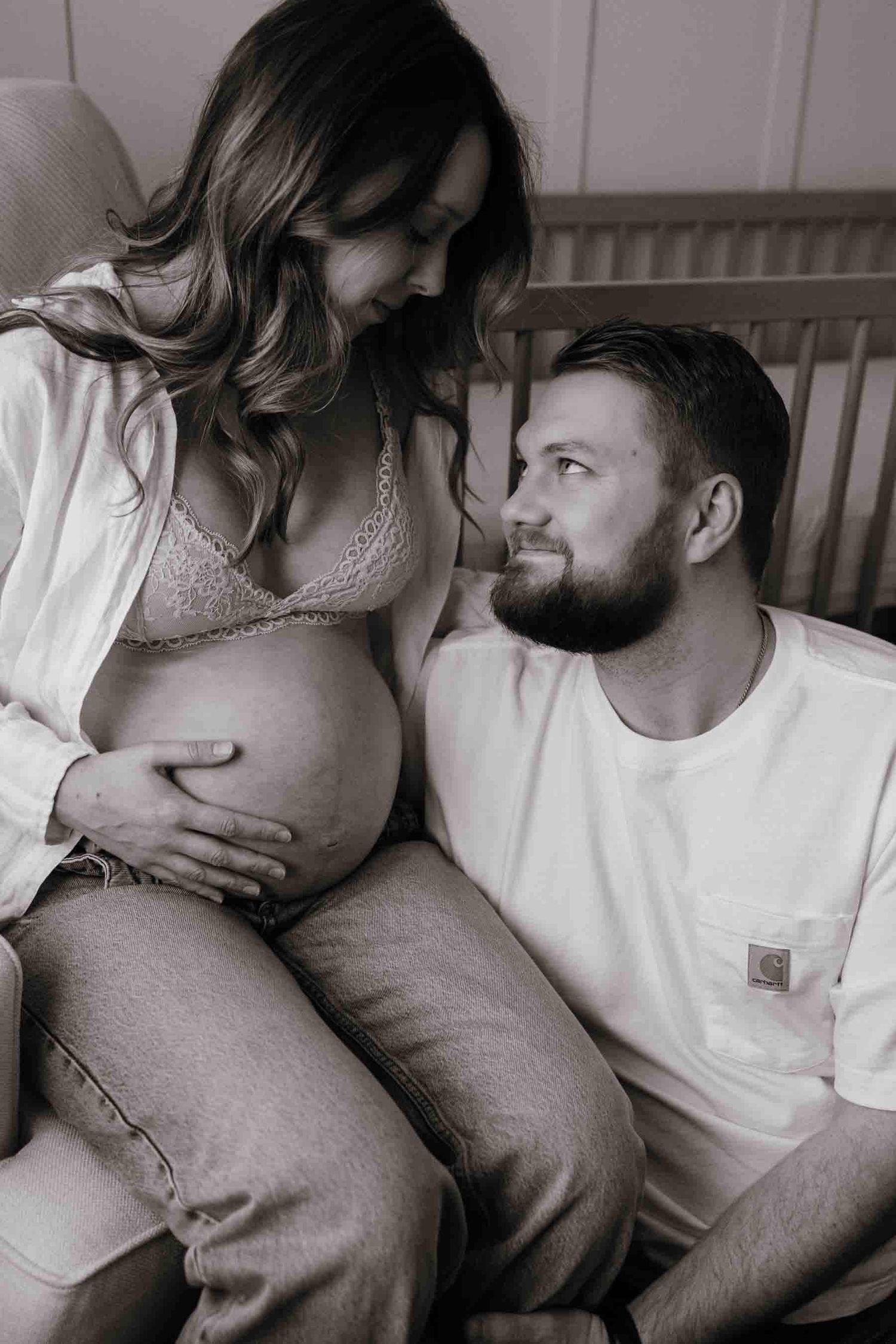 Expectant parents sharing a tender moment during an in-home maternity photography session in Toronto, celebrating anticipation.