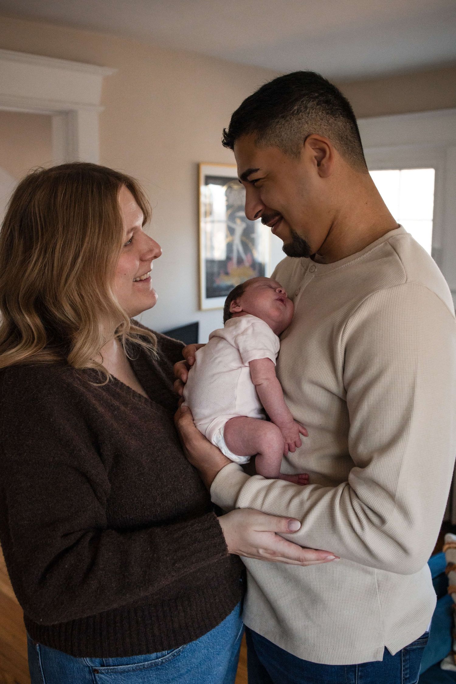 Parents admiring their newborn during an in-home newborn photography session in Toronto, capturing love, connection, and new beginnings.
