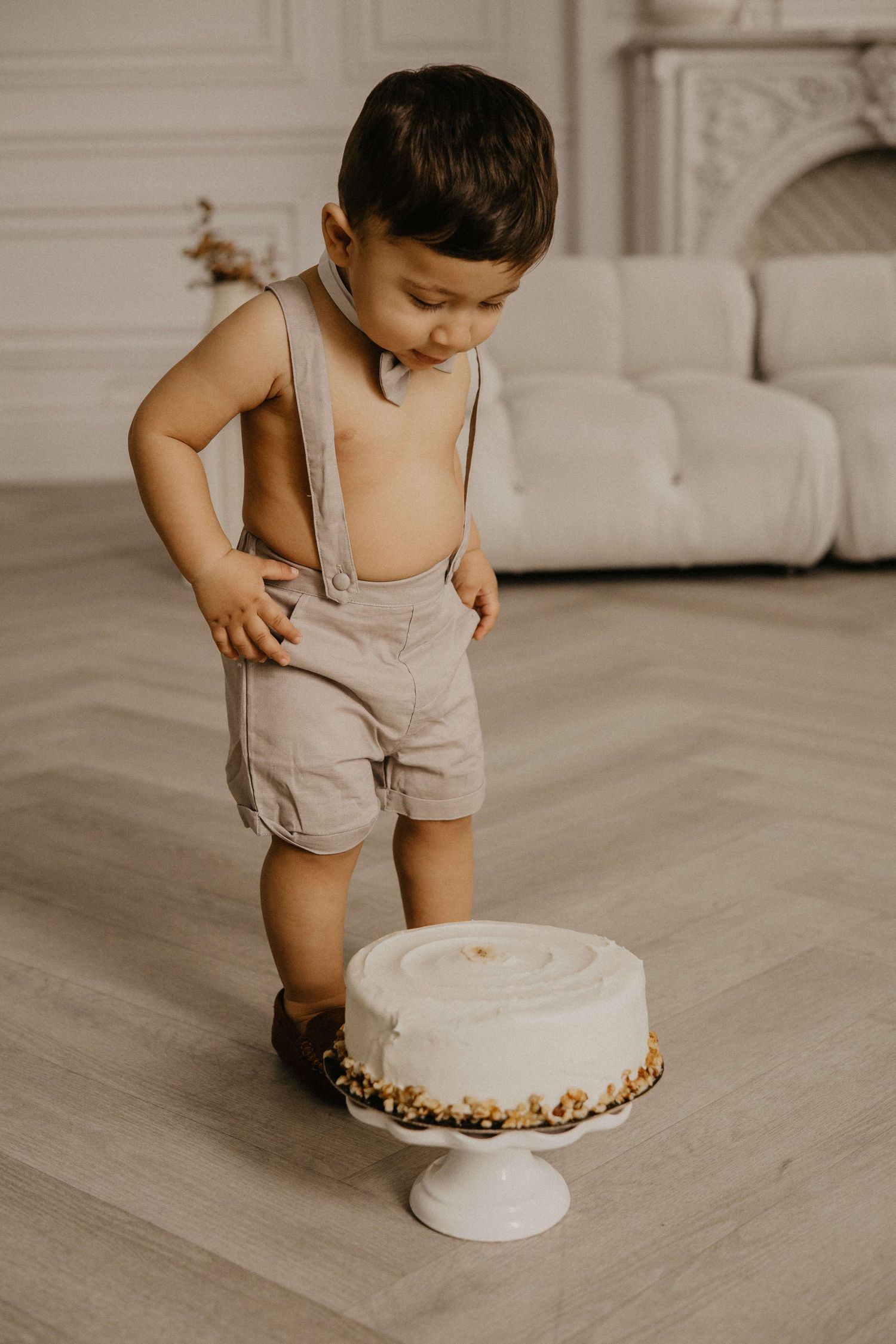 One-year-old enjoying a cake smash session at Mint Room Studios in Toronto with a simple neutral setup, timeless decor, and natural style.
