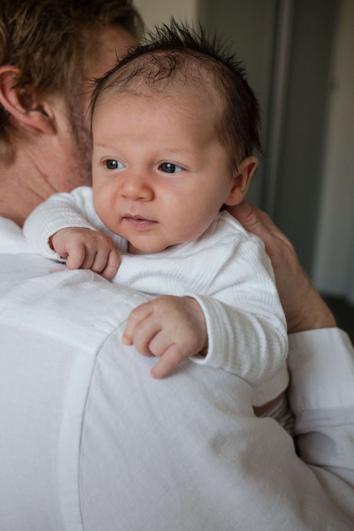 Father holding his newborn baby during a natural lifestyle photography session in Toronto.