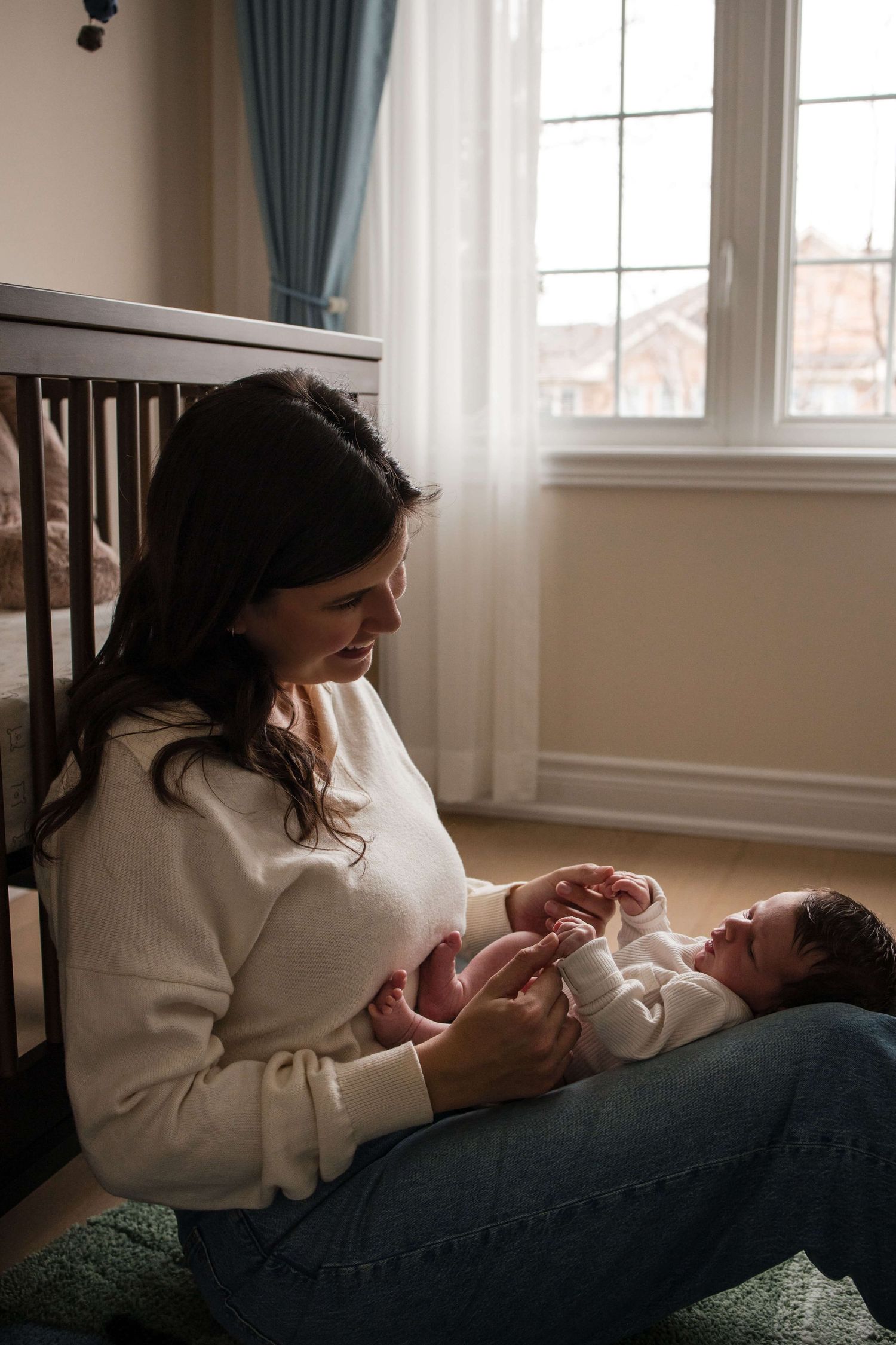 Loving mother admiring her newborn during a natural lifestyle newborn photography session in Toronto.