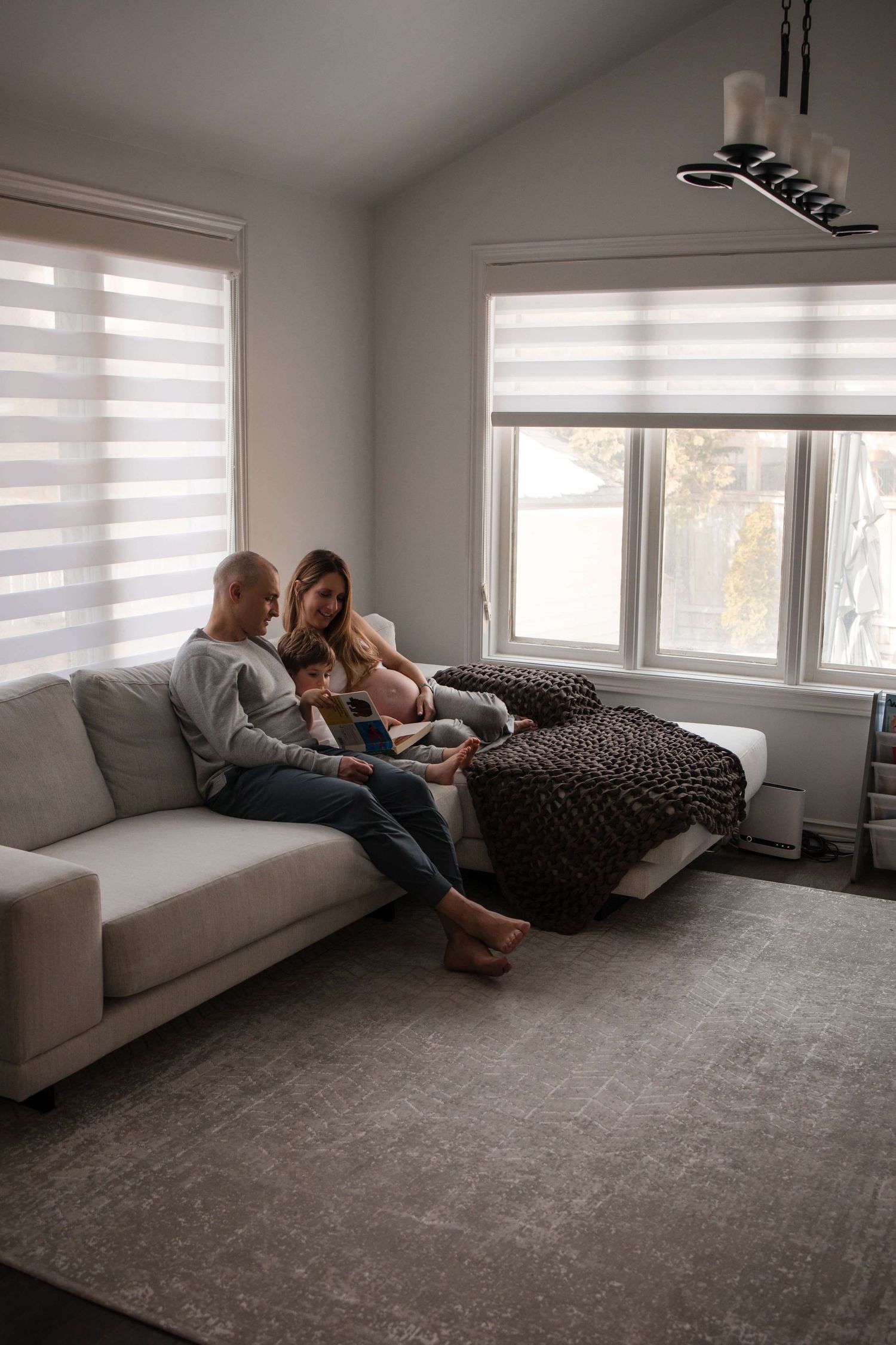 Expectant family reading together during an in-home maternity photography session in Toronto, celebrating a growing family.