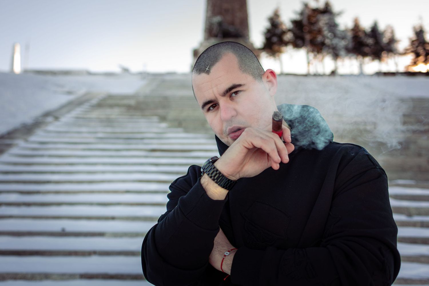 Confident male portrait with cigar on outdoor steps at sunset – cinematic portrait photography in Bulgaria.