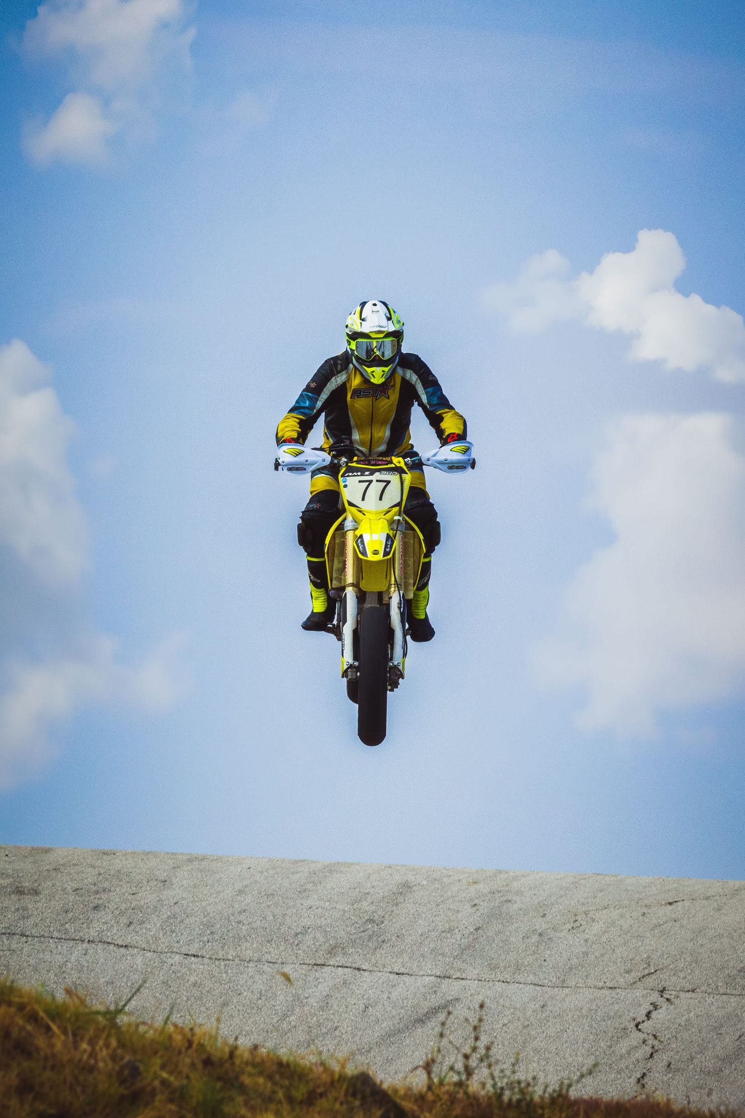Motocross rider jumping against blue sky during race event – sports photography in Bulgaria.