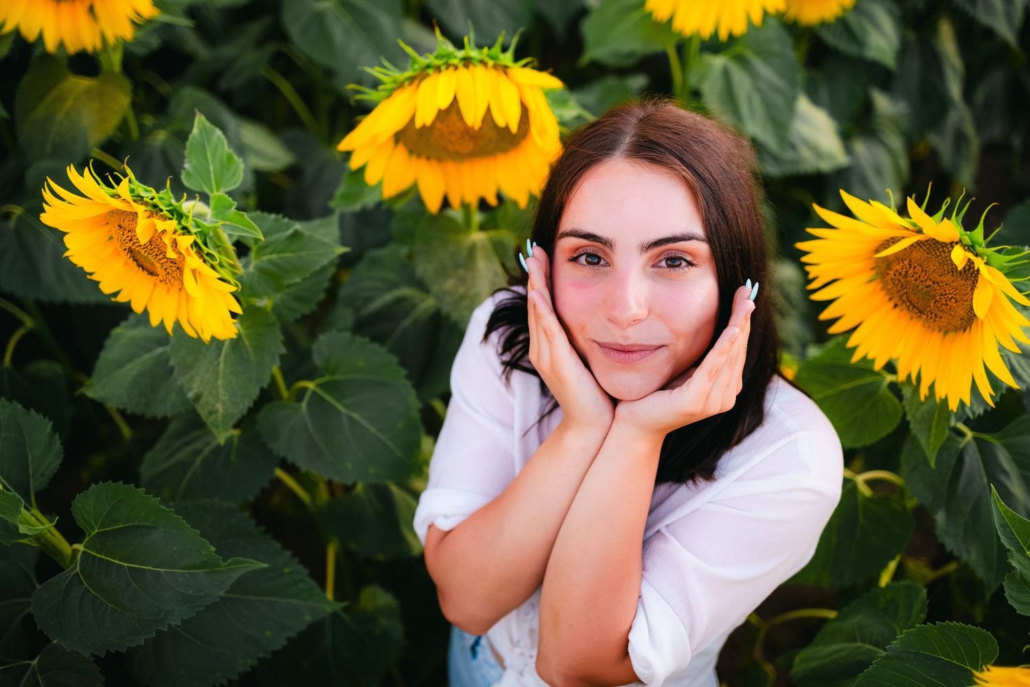 Close-up portrait of a woman framed by sunflowers with soft natural light – outdoor portrait photography. in Bulgaria