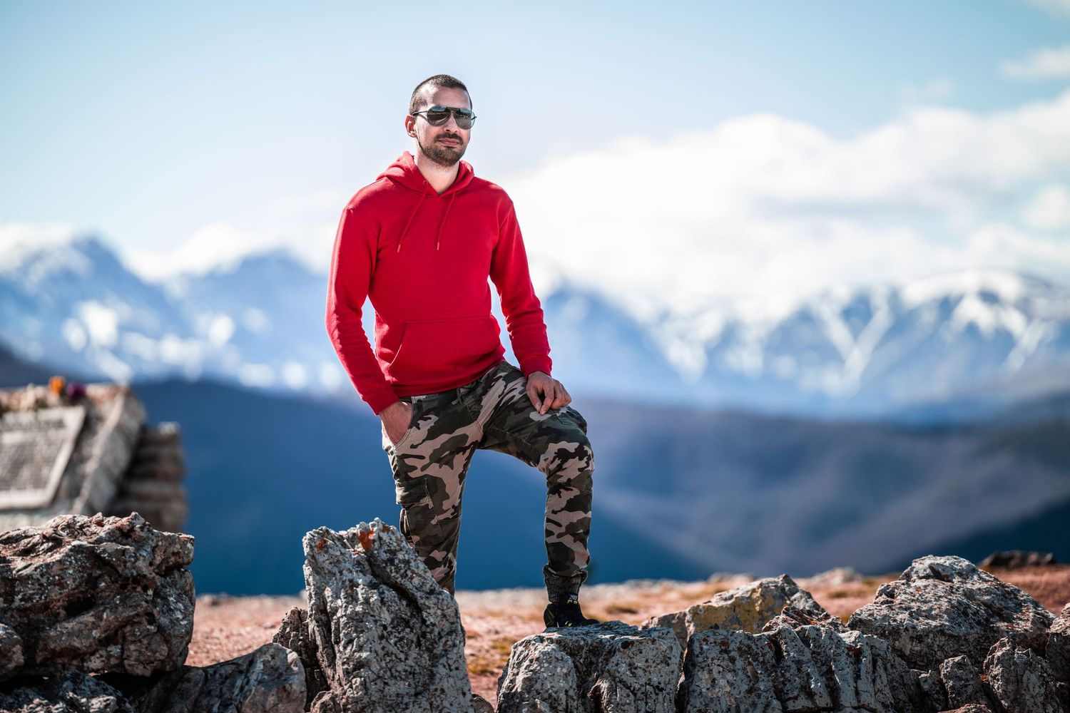 Outdoor male portrait on rocky mountain peak with dramatic landscape background – portrait photography in Bulgaria.
