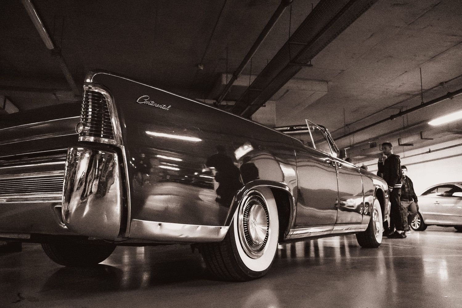 Black and white low-angle shot of vintage classic car in underground garage – automotive photography in Bulgaria.
