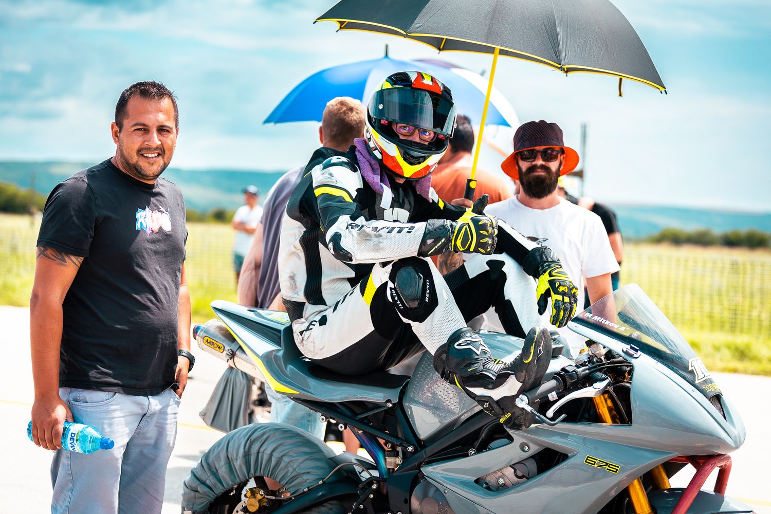 Rider and team moment before or after race session, capturing the human side of competitive motorsport in Bulgaria.