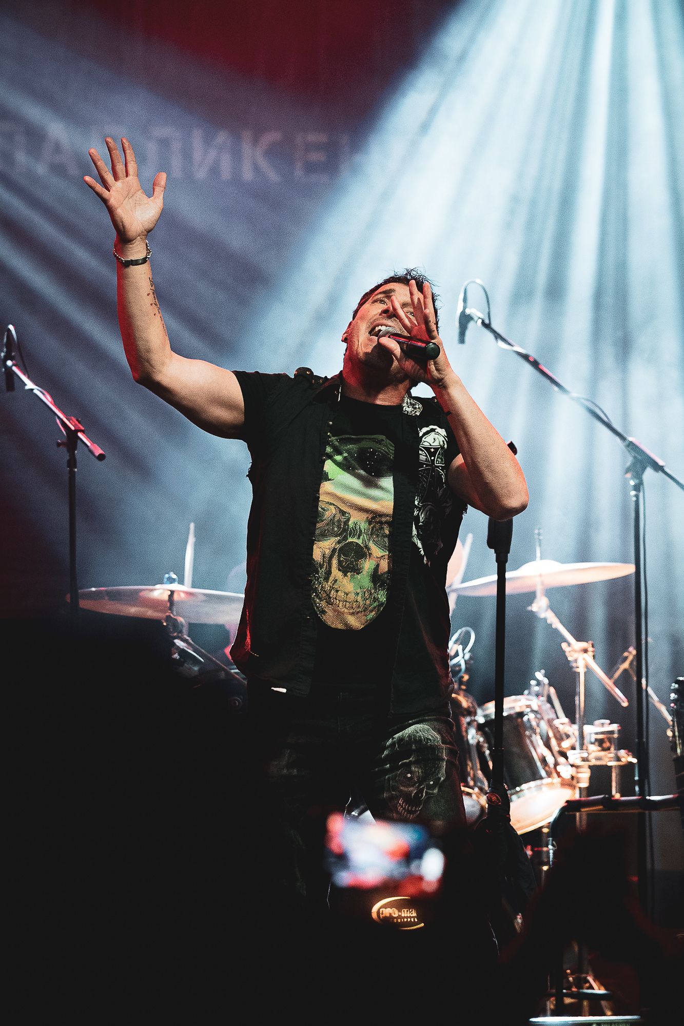 Lead vocalist engaging the audience under strong stage lights, capturing energy and connection in Bulgaria.