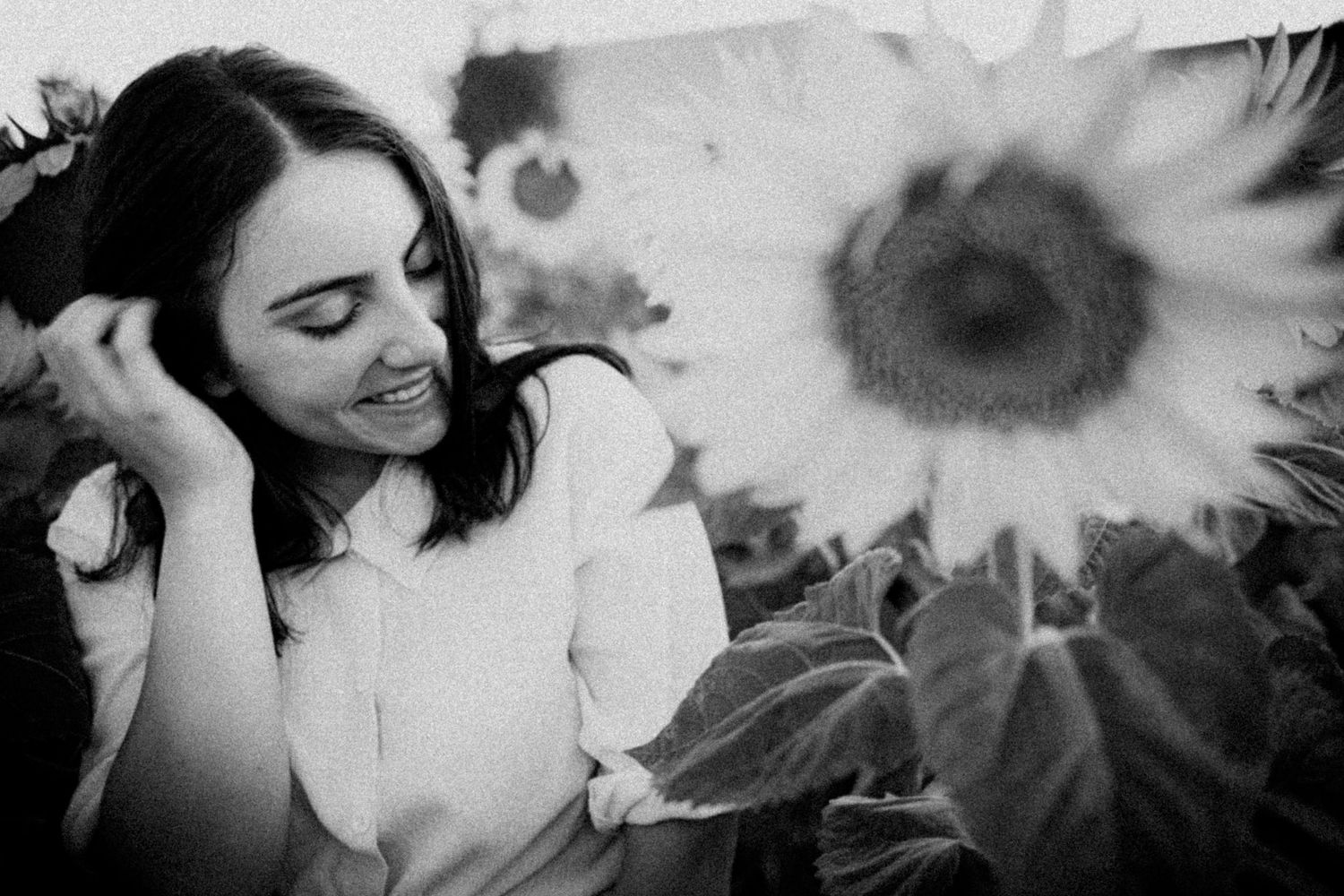 Black and white portrait of woman smiling among sunflowers – portrait photography in Bulgaria.