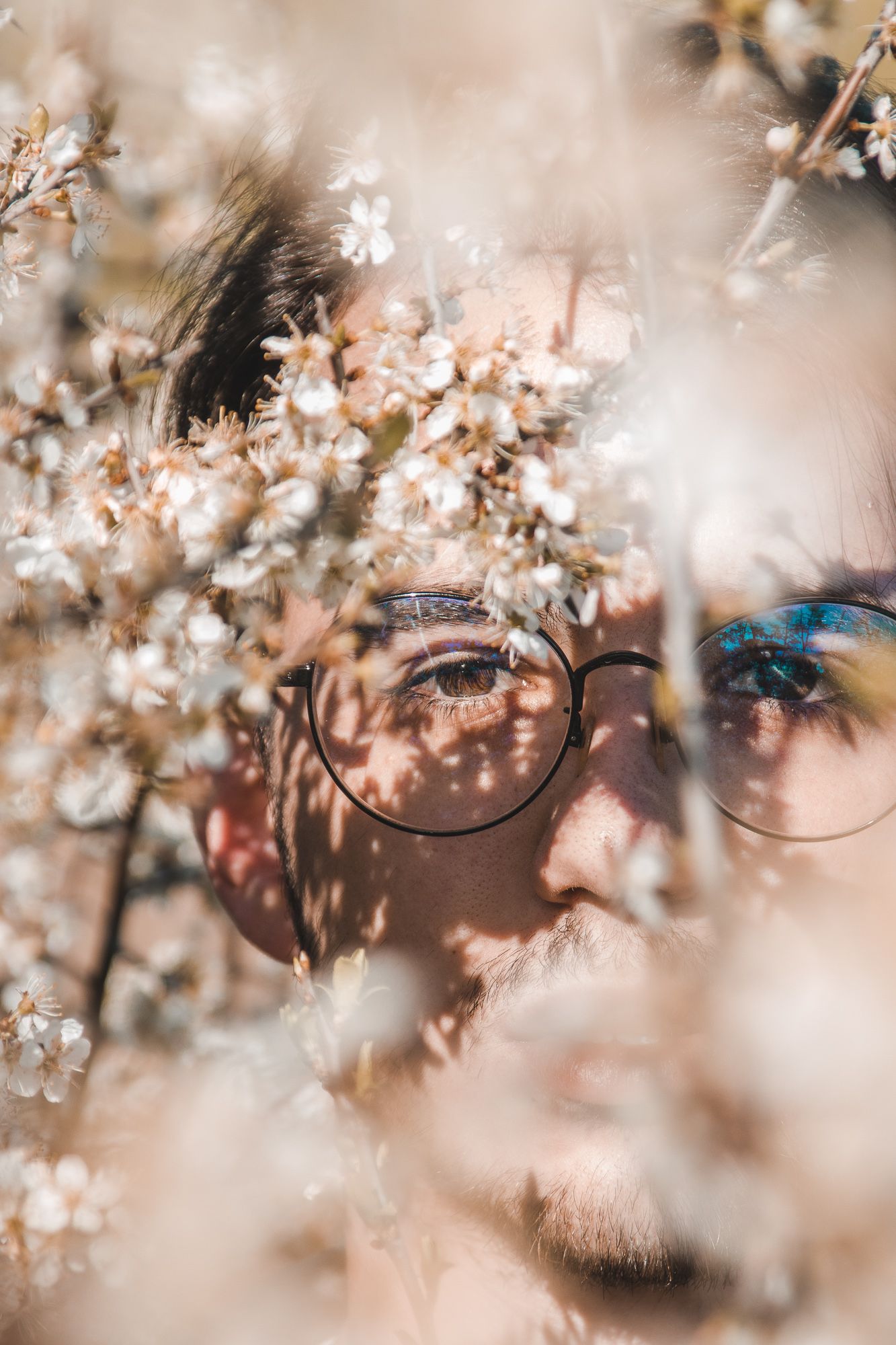 Creative close-up portrait through branches with soft foreground blur – artistic portrait photography in Bulgaria.