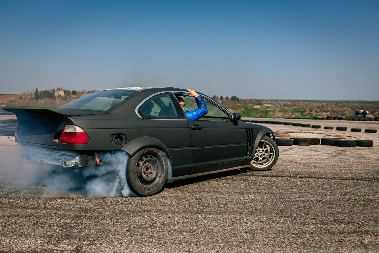 Drift car performing burnout with tire smoke on race track – motorsport photography in Bulgaria.