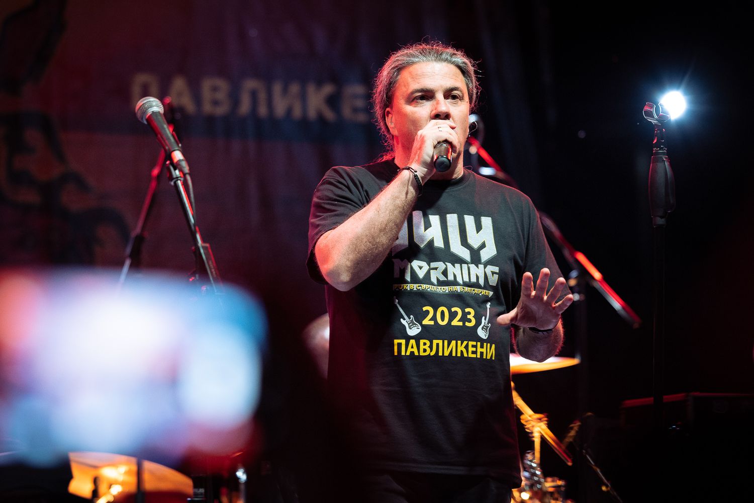 Lead vocalist performing live on stage, captured mid-performance with focused lighting and strong stage presence in Bulgaria.