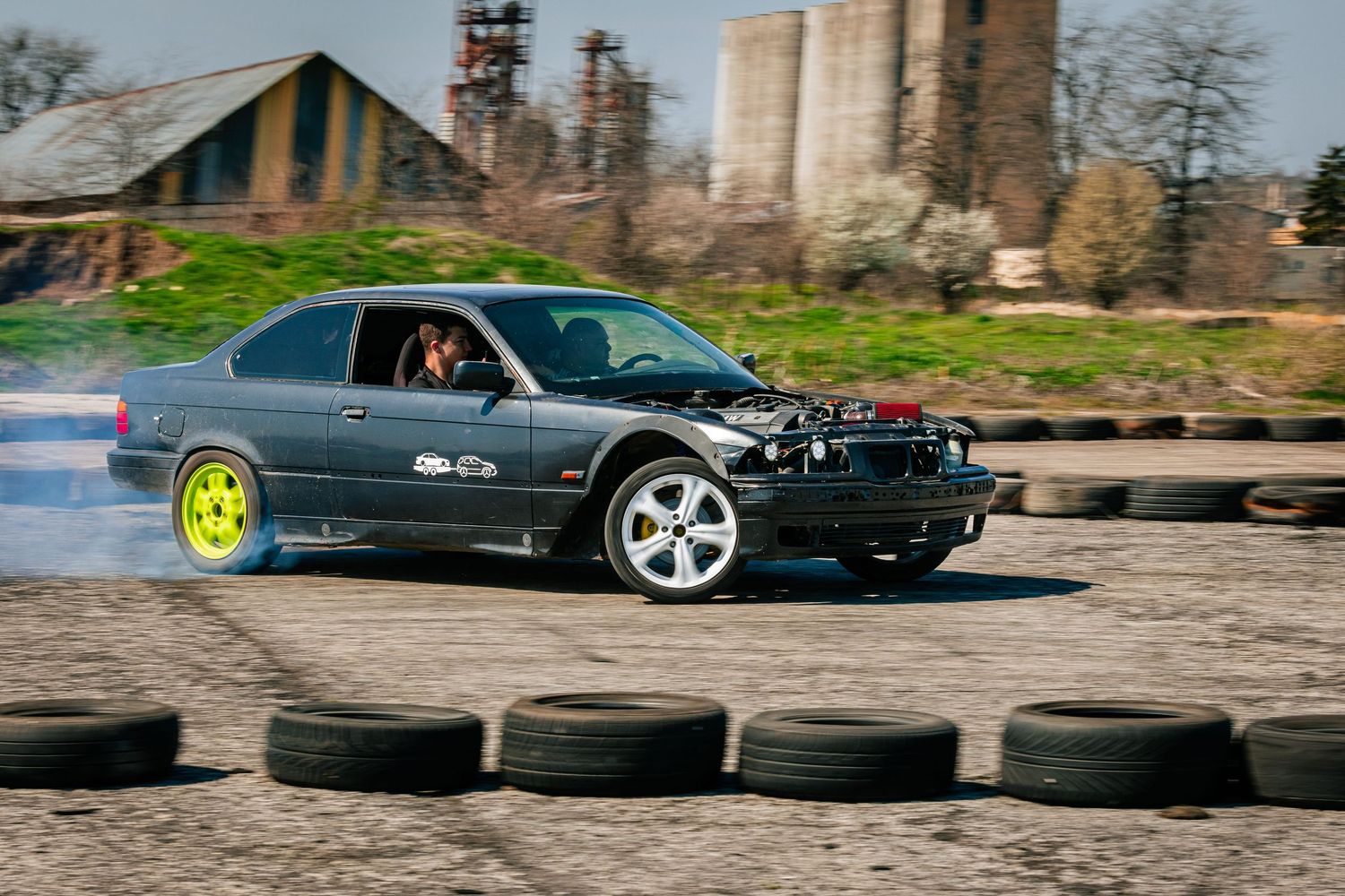 Drift car sliding through corner on race track with tire barriers – sports photography in Bulgaria.