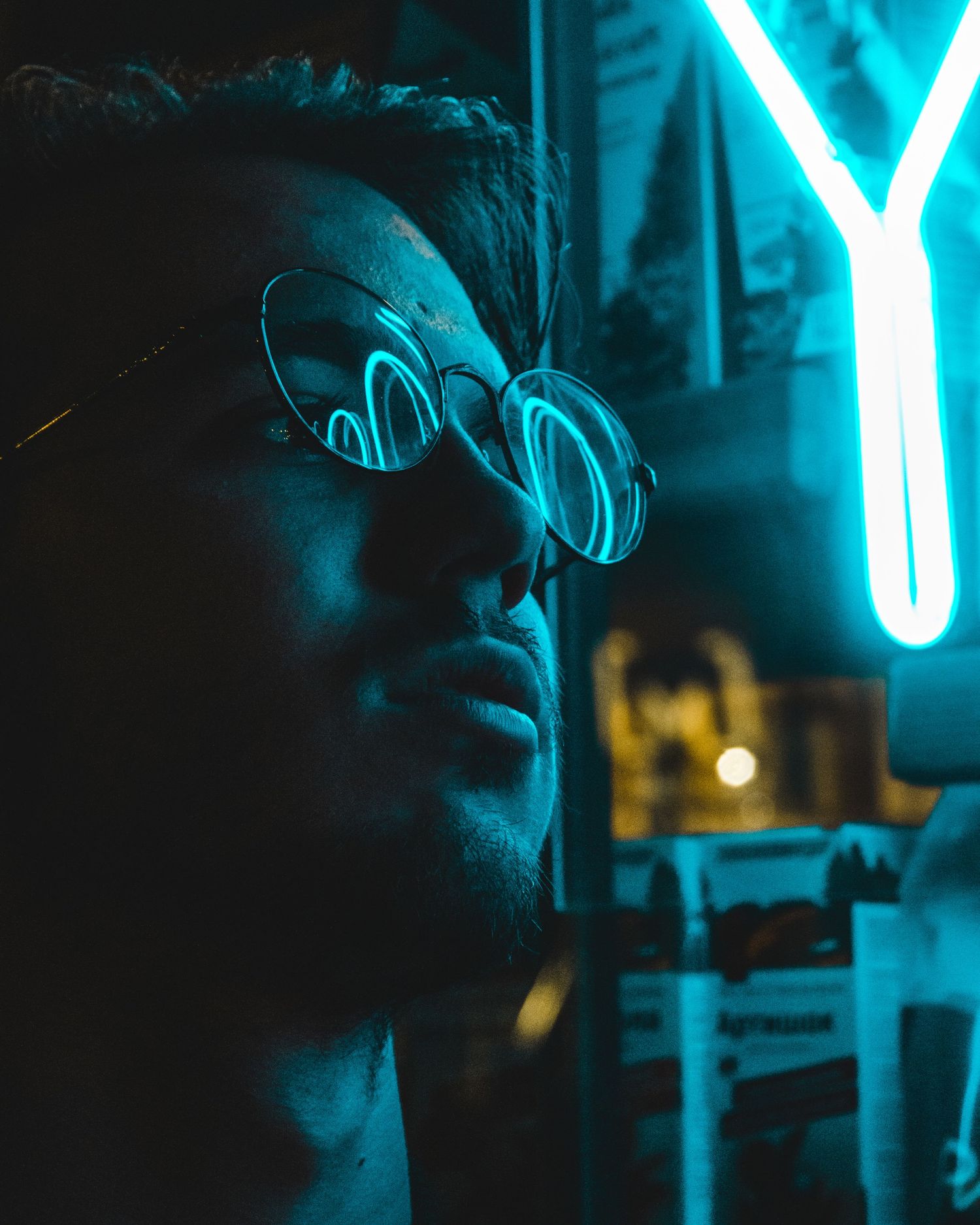 Moody night portrait of a man illuminated by blue neon light reflections – cinematic portrait photography in Bulgaria.