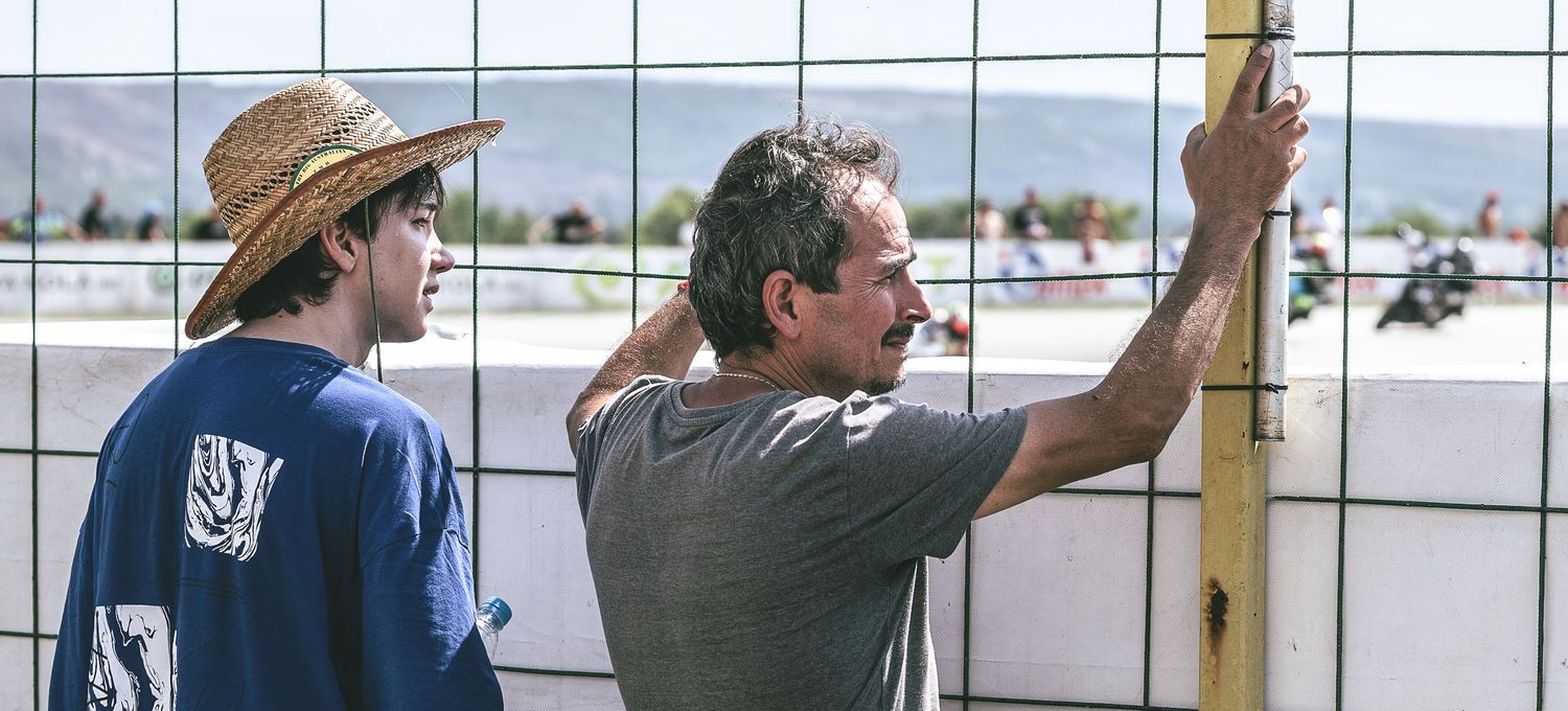 Spectators watching motorsport race from behind safety fence – sports photography in Bulgaria.