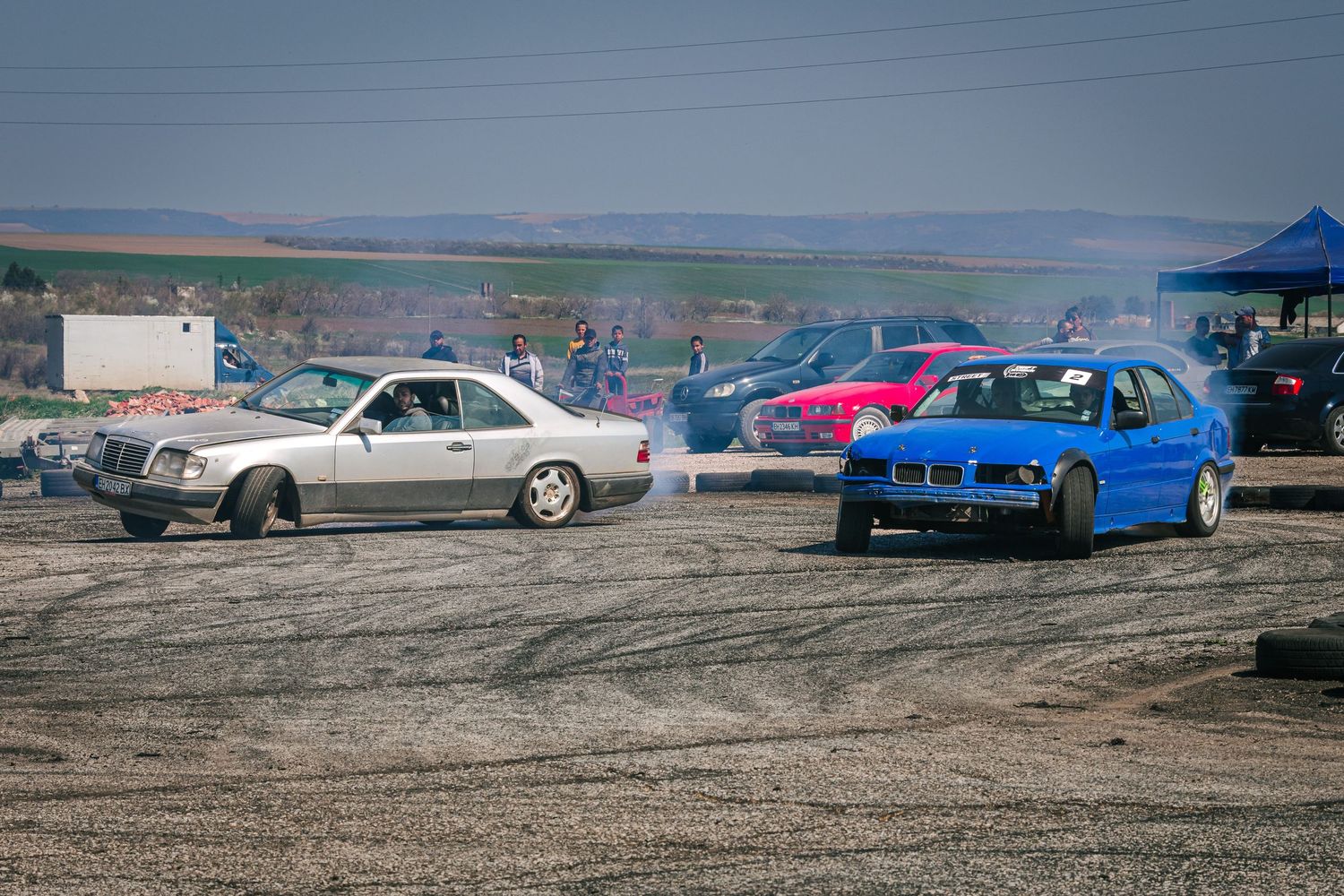 Multiple drift cars in action during motorsport event with tire smoke and spectators – sports photography in Bulgaria.