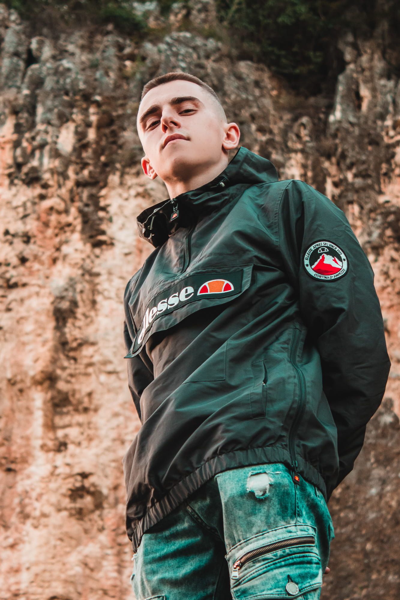 Confident male portrait with textured rocky background in warm light – outdoor portrait photography in Bulgaria.