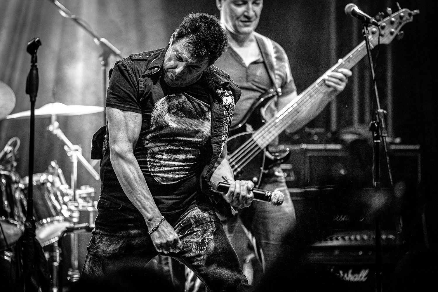 Dynamic black and white moment between band members mid-performance, emphasizing rhythm and movement in Bulgaria.