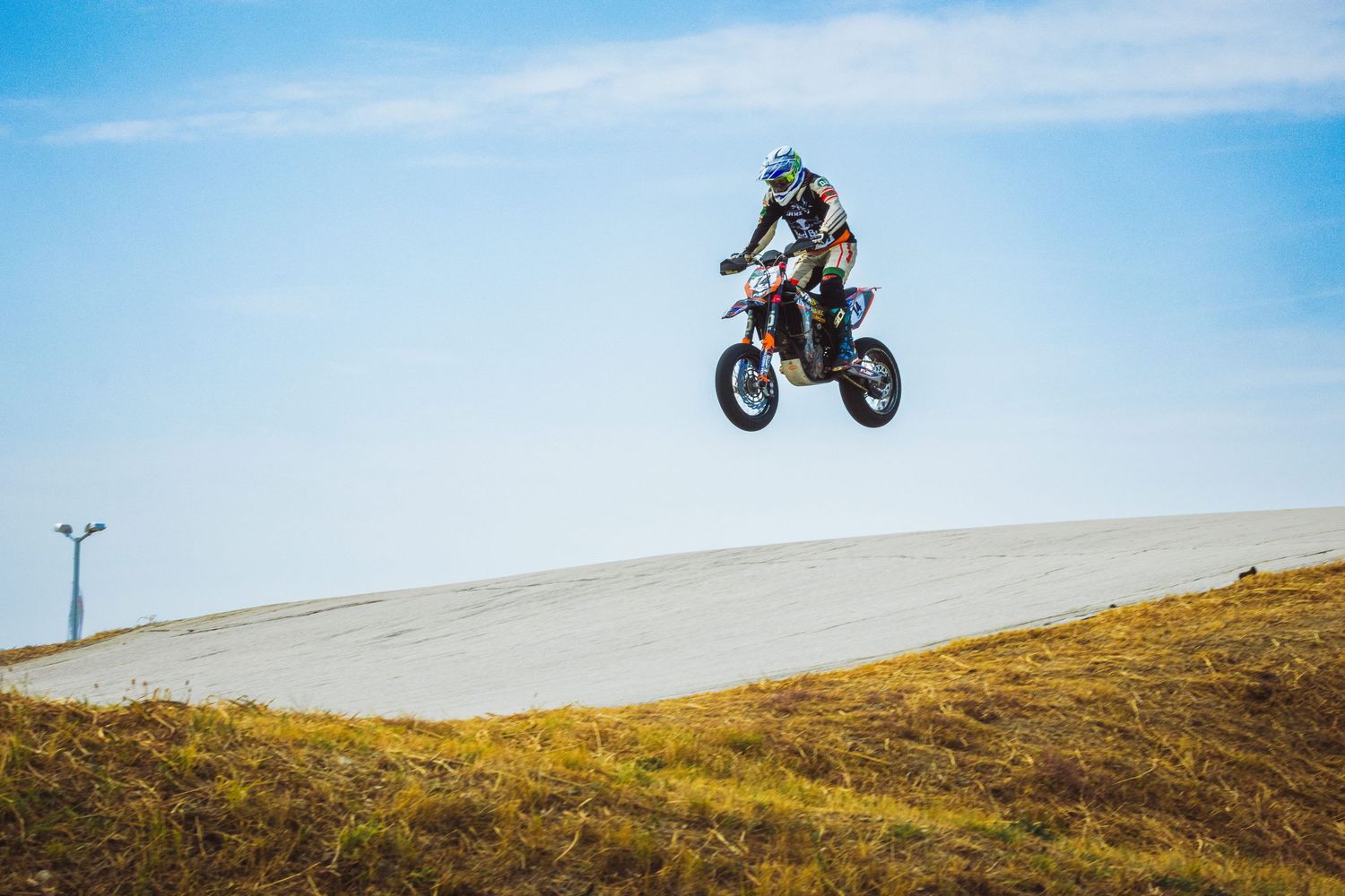 Motocross rider jumping over dirt track during competition – sports photography in Bulgaria.