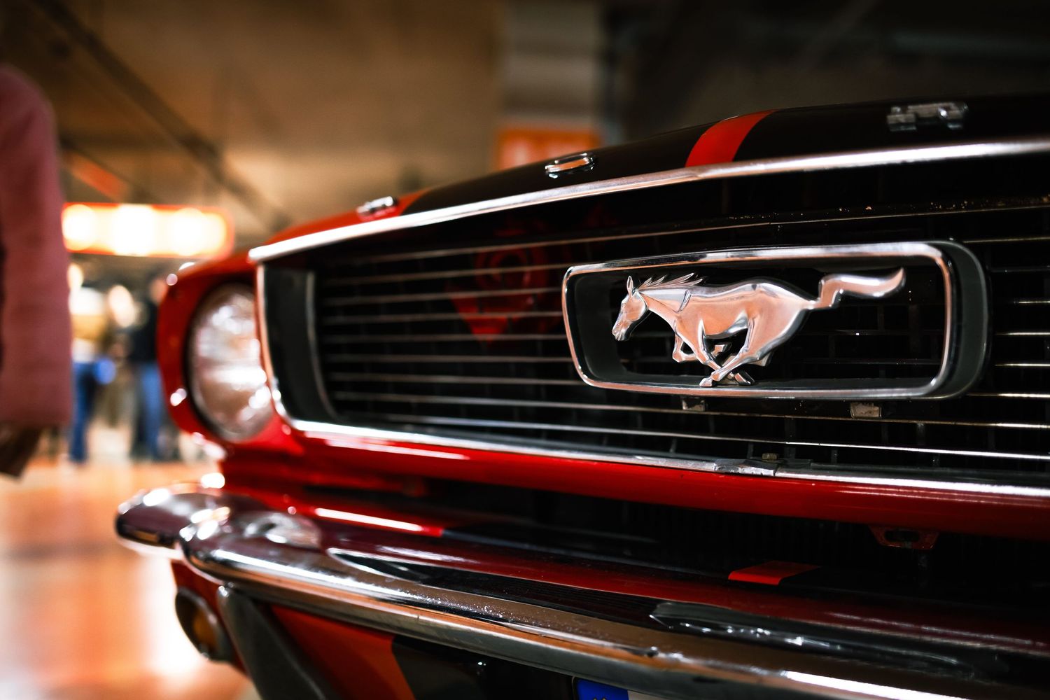 Close-up of Ford Mustang grille emblem at indoor car event – automotive photography in Bulgaria.