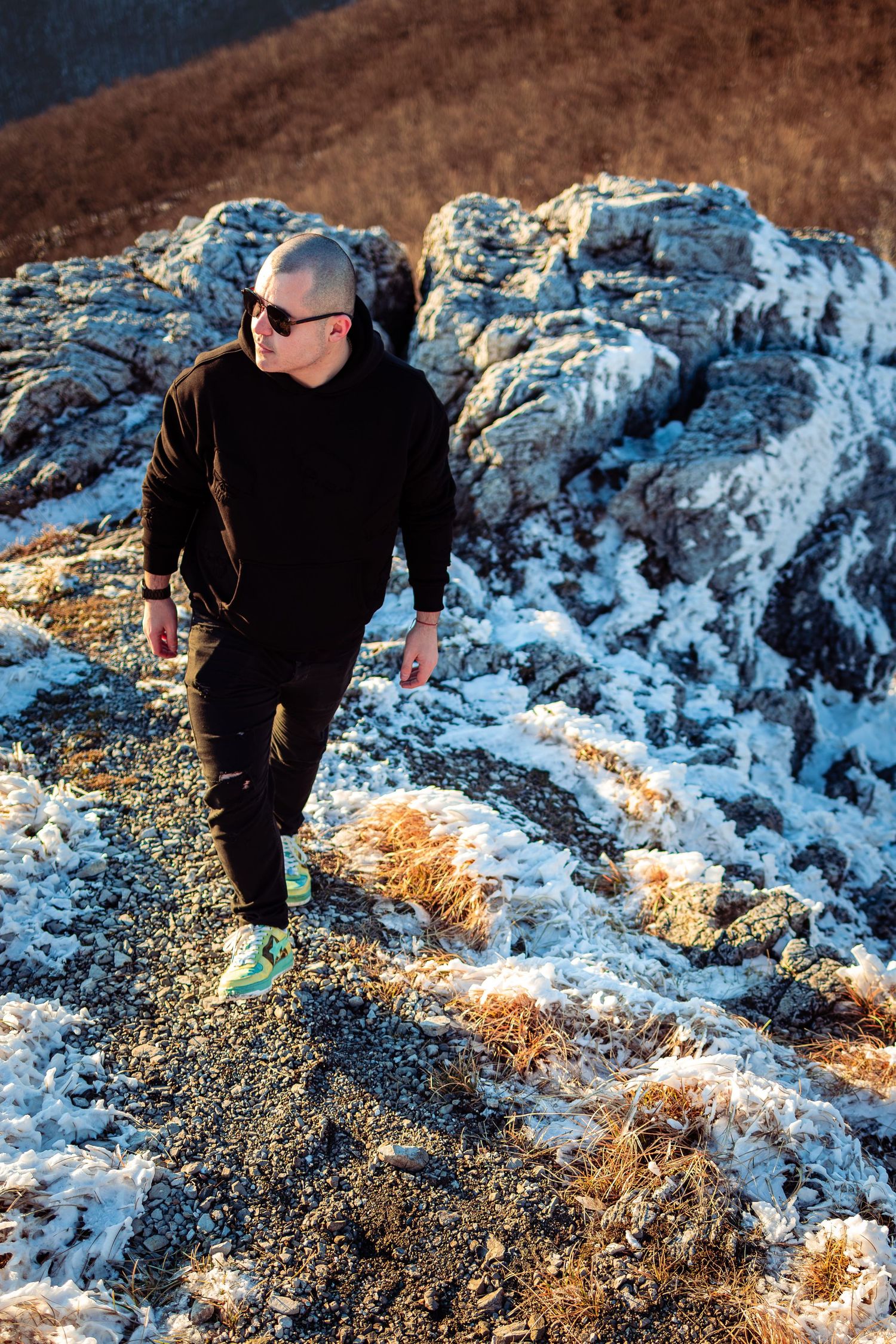 Cinematic outdoor portrait of a man on mountain rocks during golden hour – dramatic portrait photography in Bulgaria.