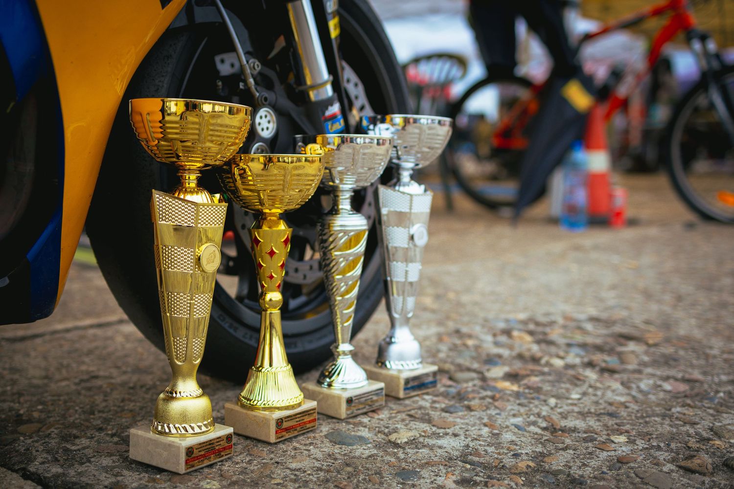 Motorsport trophies displayed beside racing motorcycle after competition – sports photography in Bulgaria.