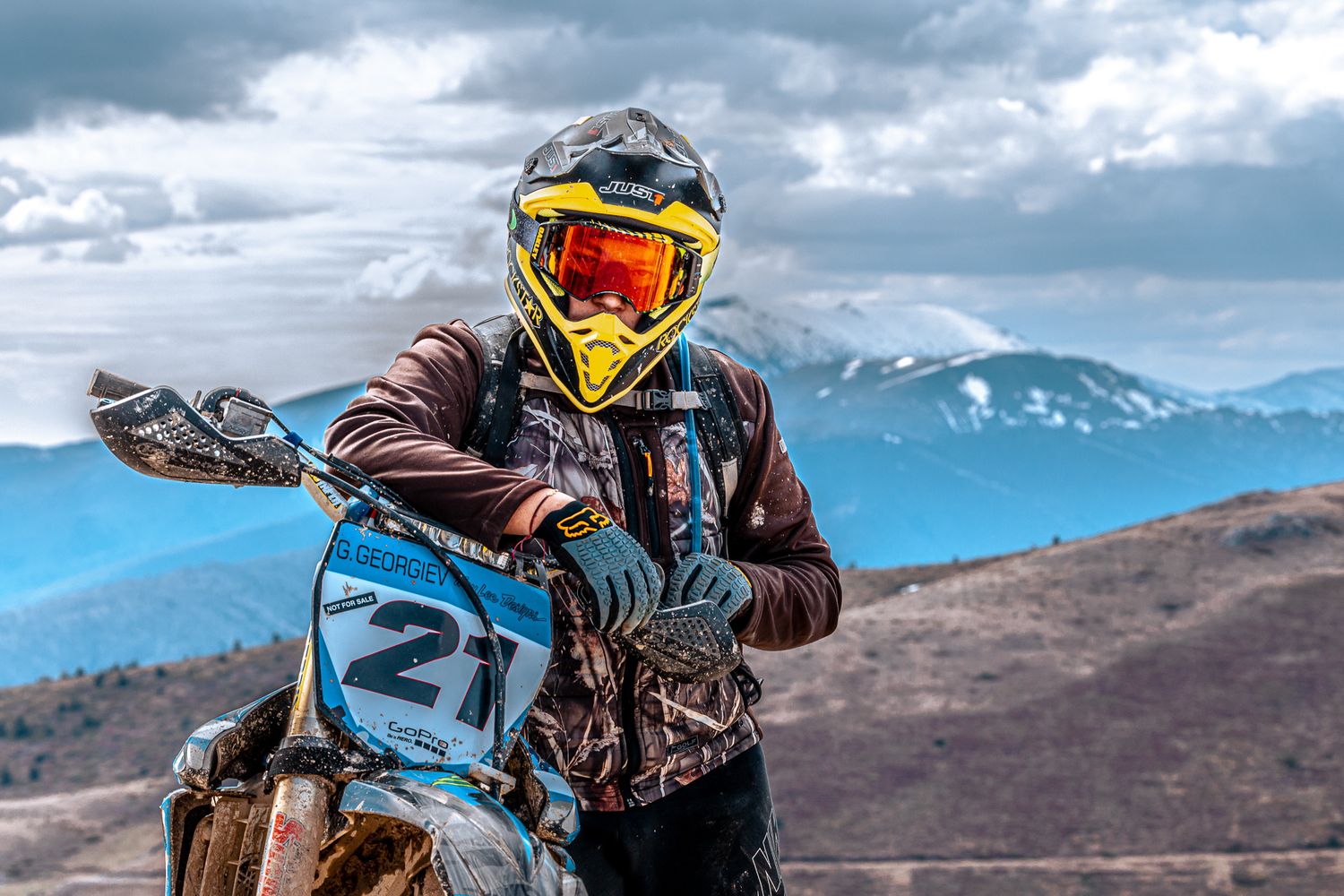 Environmental portrait of a motocross rider with mountain landscape background – outdoor portrait photography in Bulgaria.