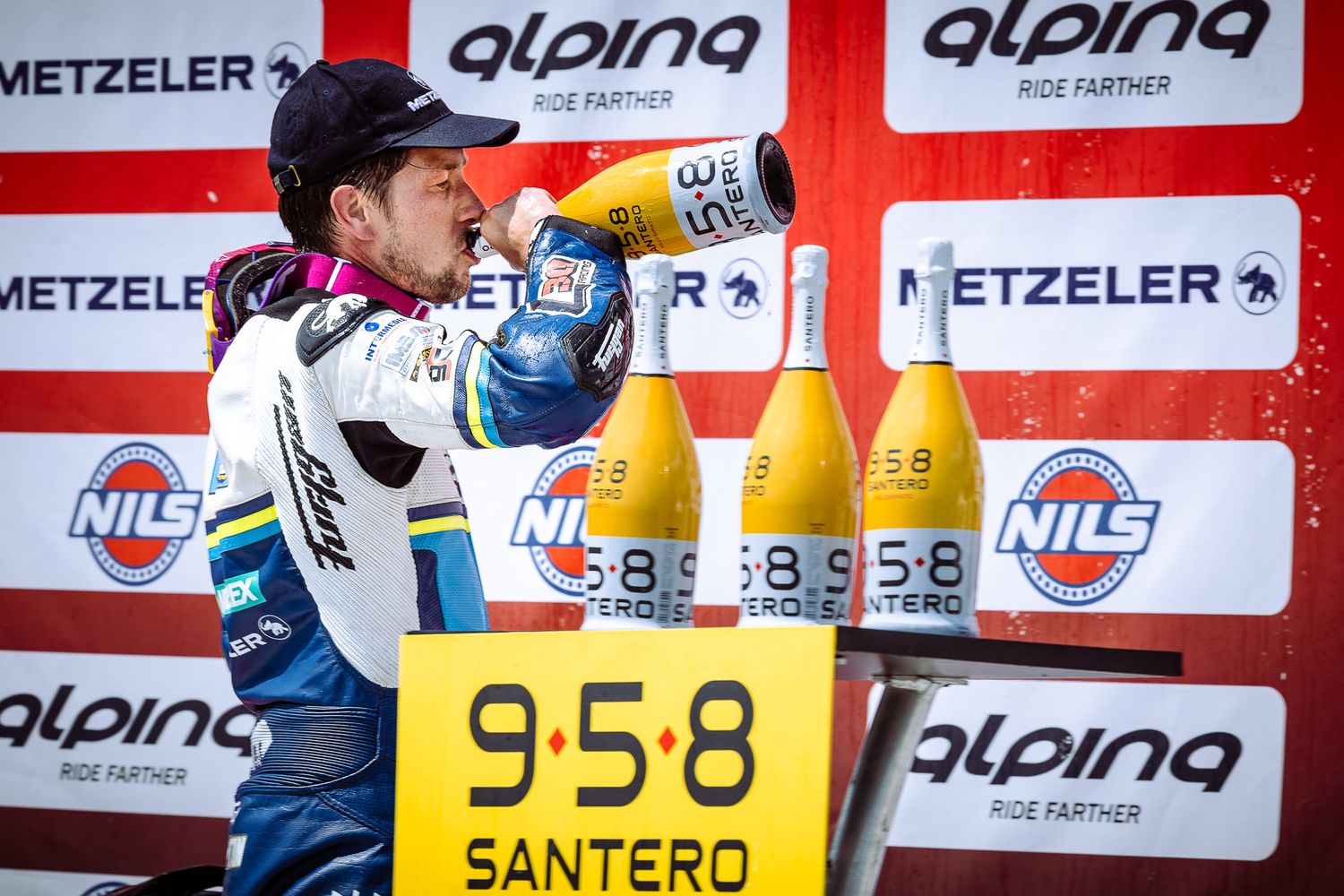 Podium champagne celebration against official sponsor backdrop, capturing victory and competitive intensity in Bulgaria.