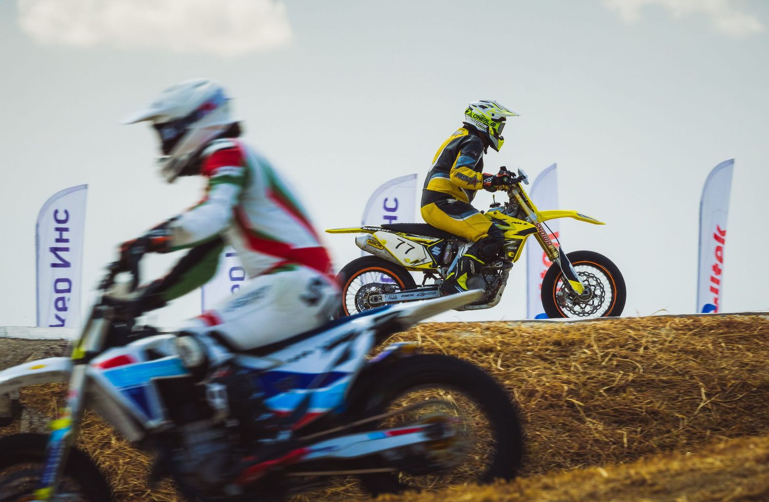 Motocross riders racing side by side on dirt track during competition – sports photography in Bulgaria.