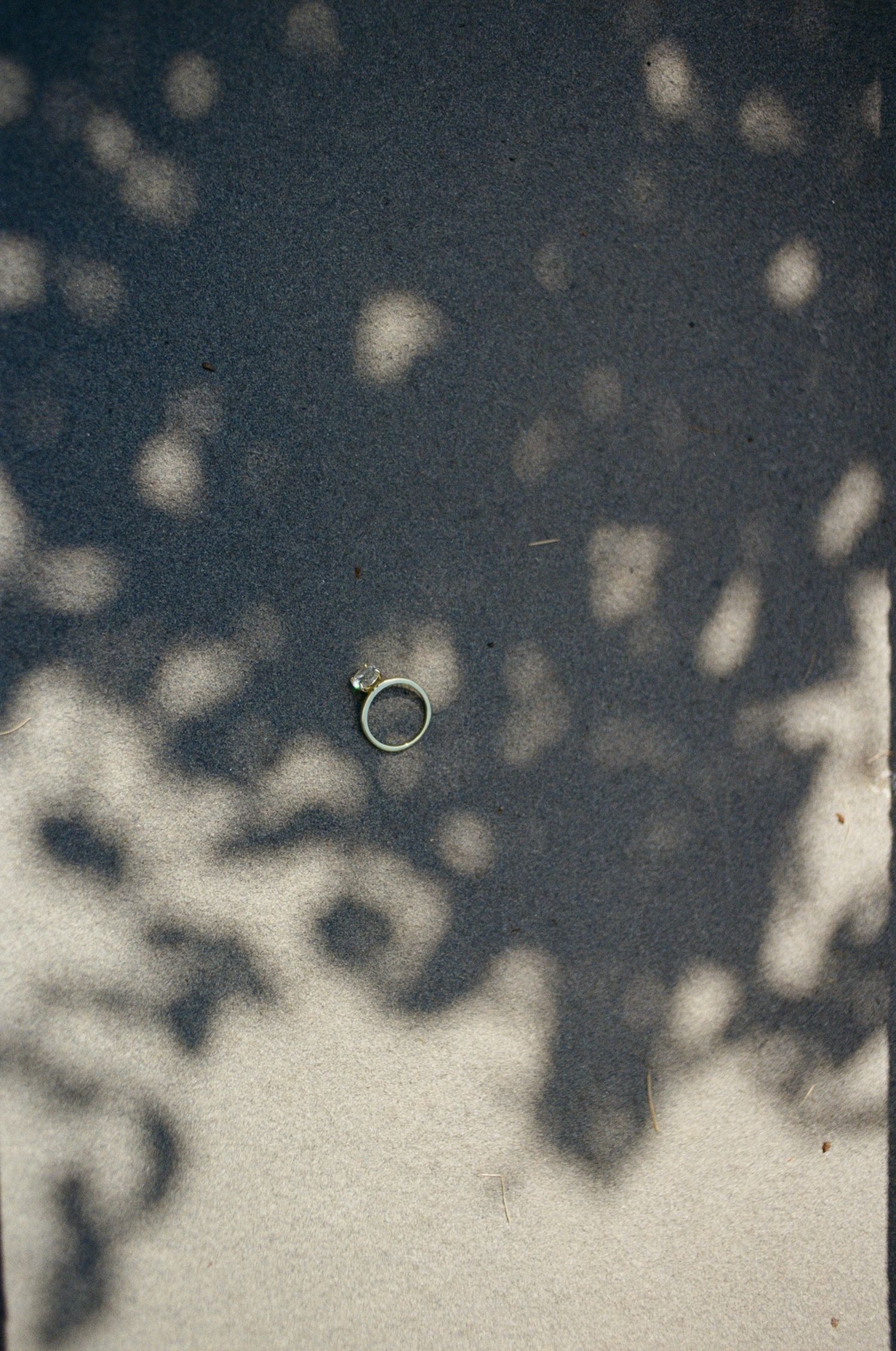 Abstract shadows and light patterns creating a dappled effect against a light colored surface.