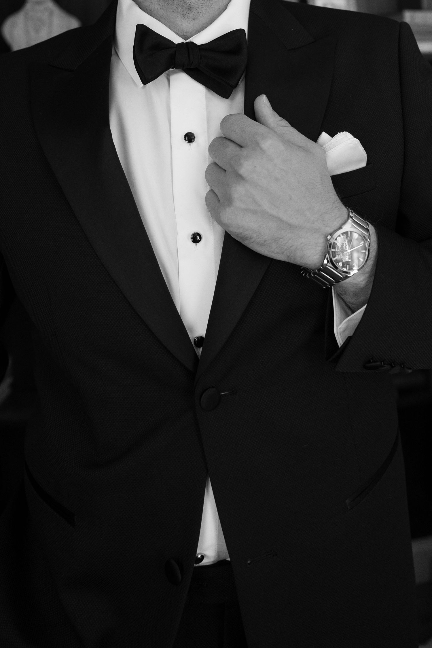 Close-up details of formal black tuxedo with bow tie and white dress shirt.