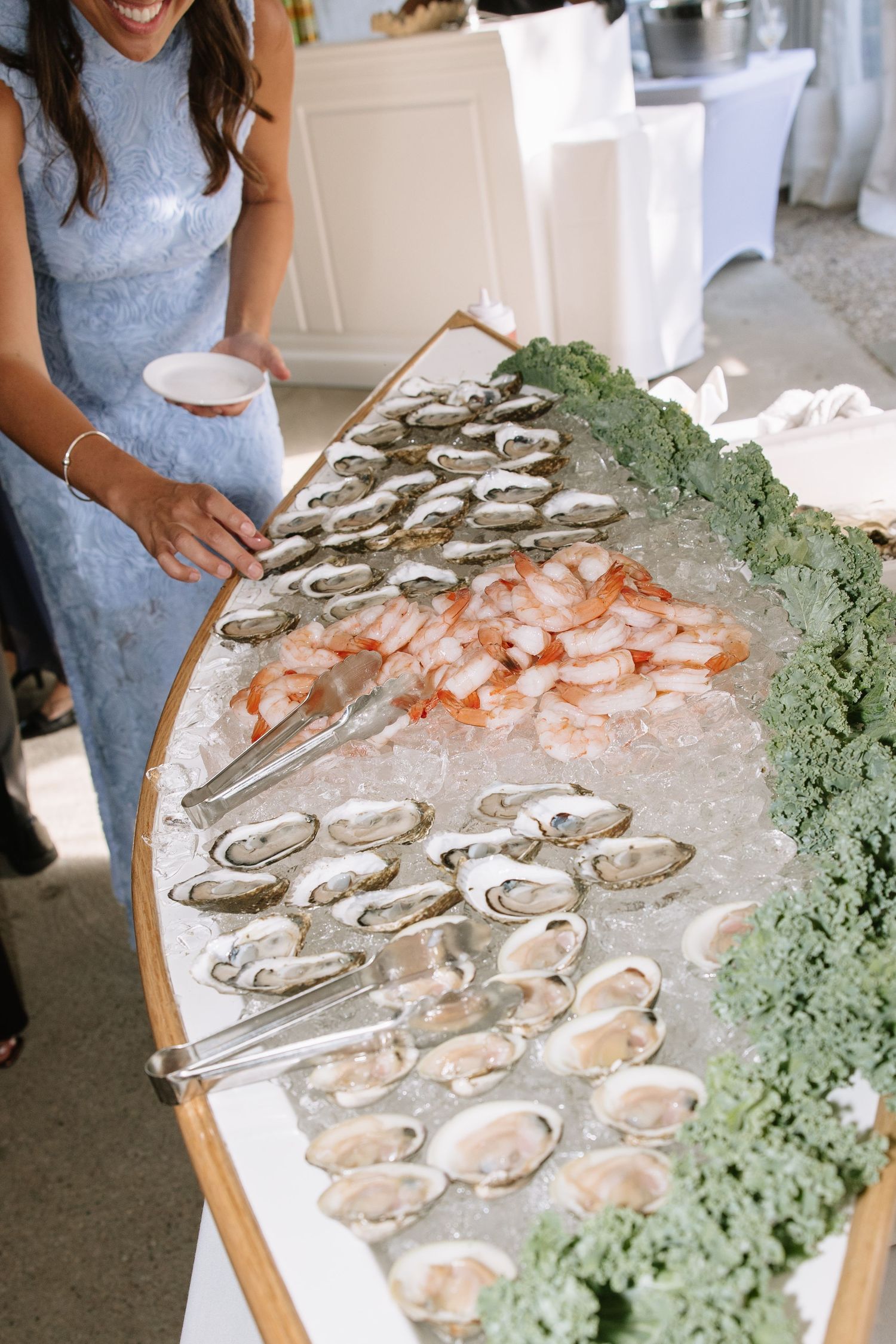 Elegant raw bar display with oysters and shrimp on ice at wedding.