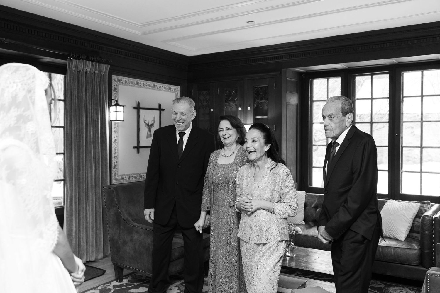 Formal gathering in an elegant wood-paneled room with traditional decor and window treatments.
