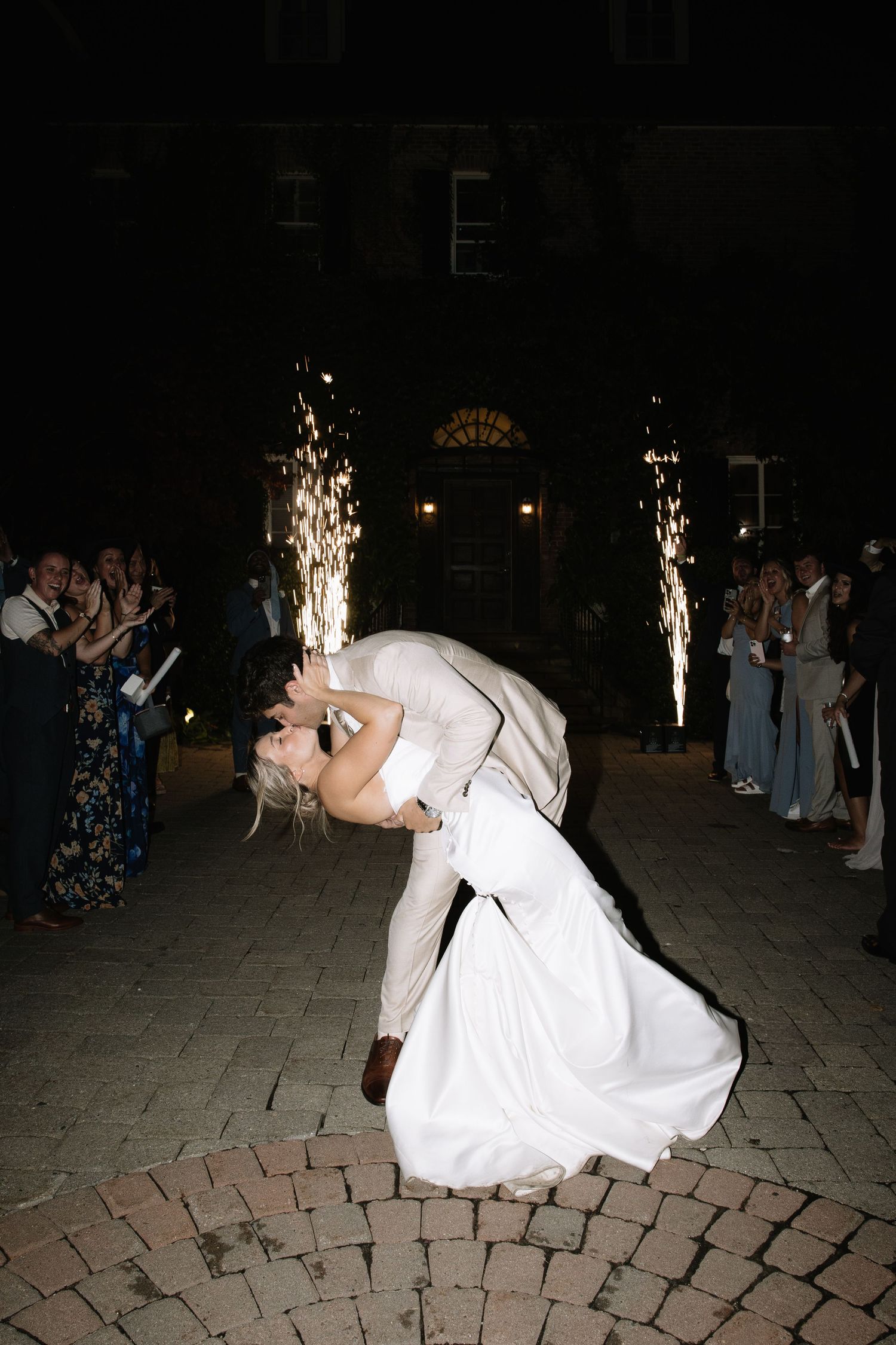 Romantic dance dip on outdoor patio with sparkler fountains in background.