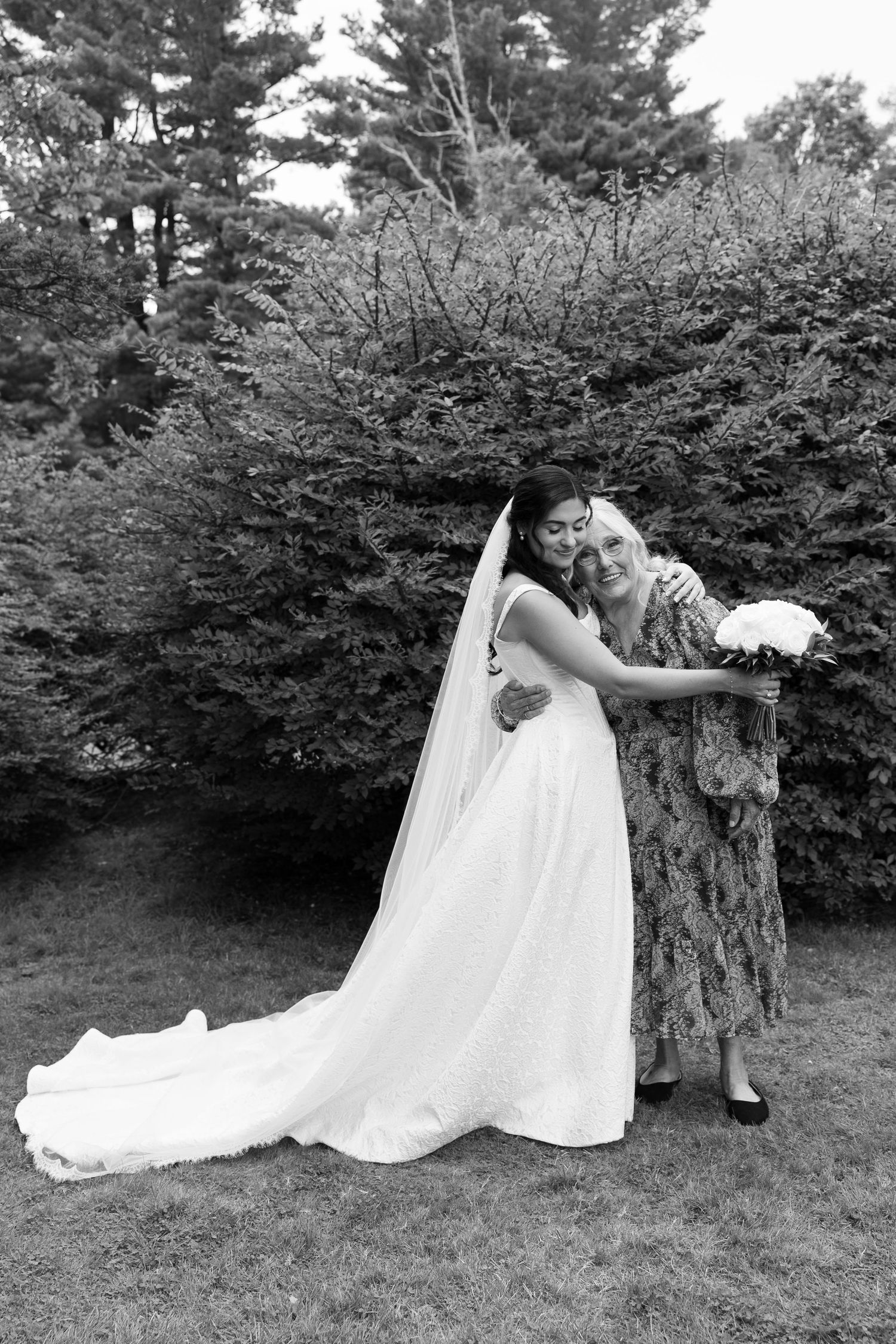 Creative black and white wedding photos taken near a large tree trunk in a natural setting.