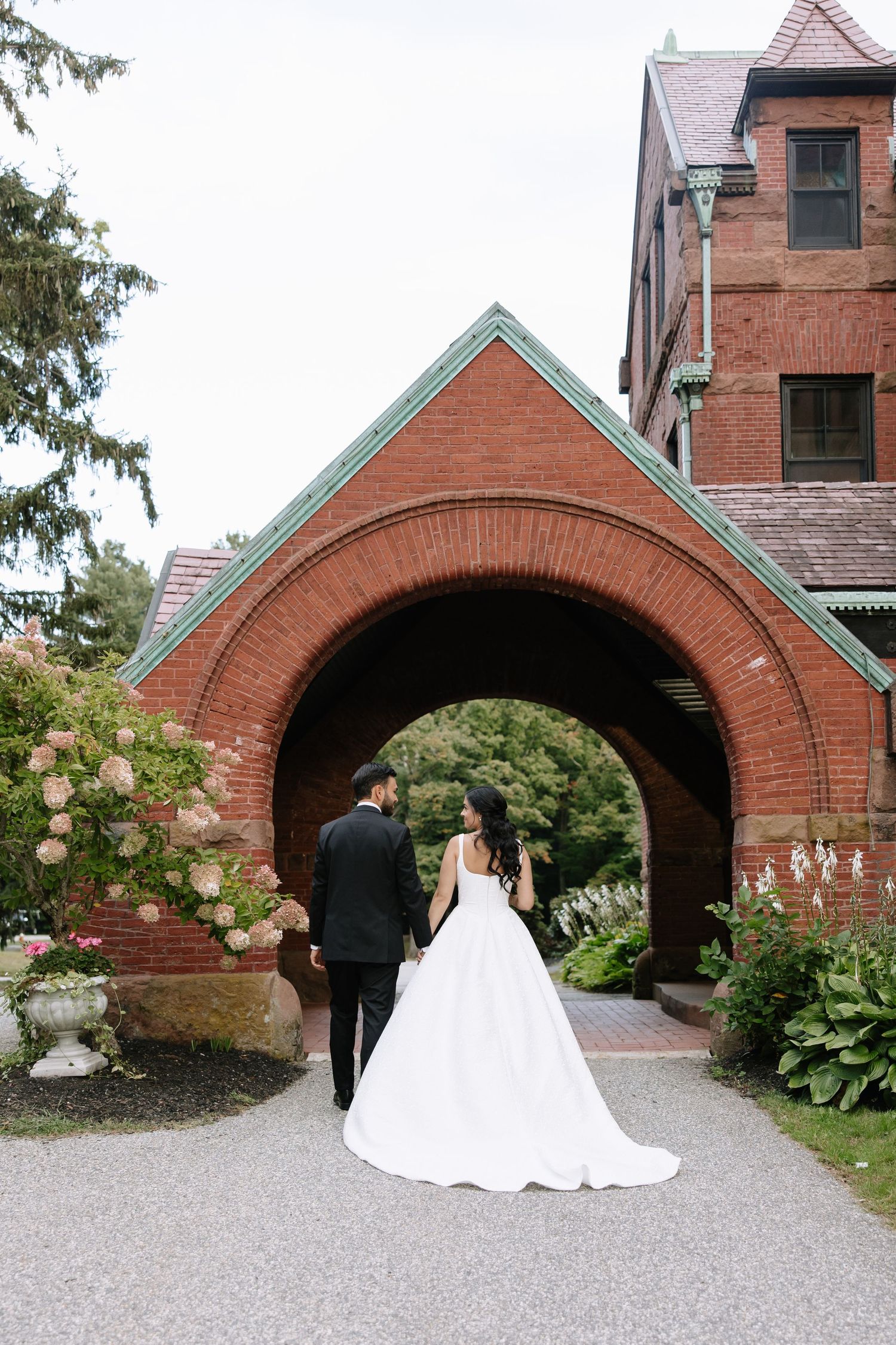 Series of wedding photos showing couple under beautiful brick archways of historic building.