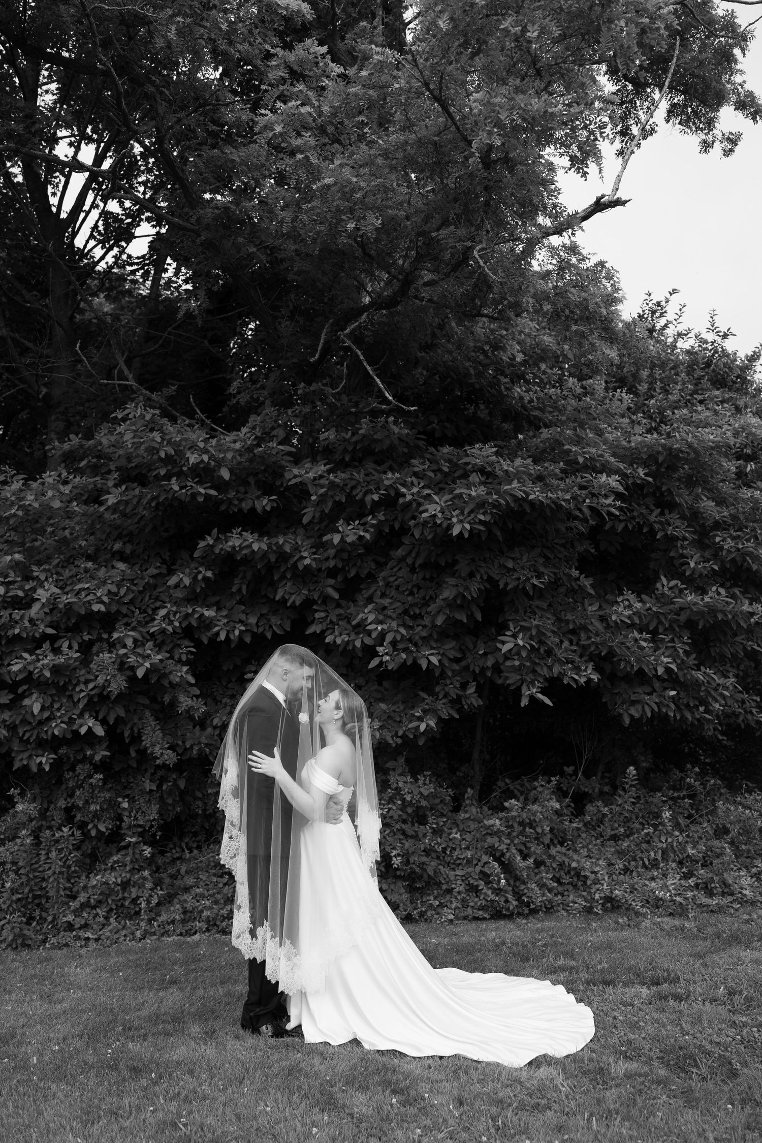 Romantic black and white wedding photos captured in a natural outdoor setting.