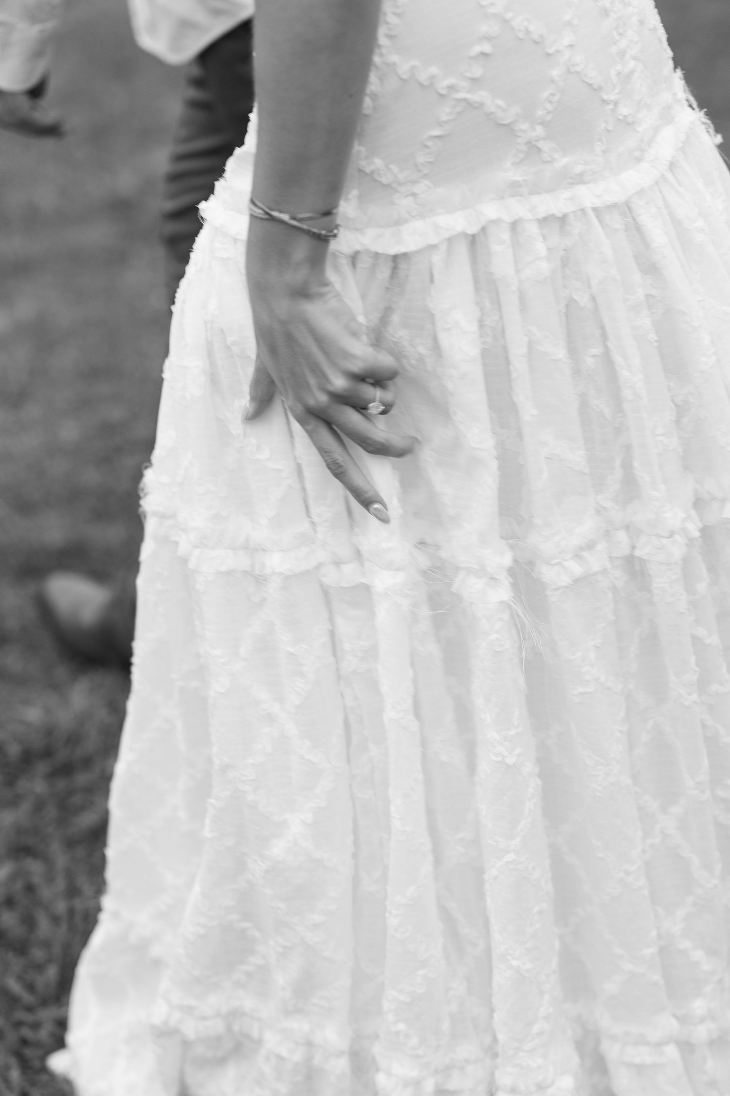 Detail shot of delicate lace layers on a white wedding dress.
