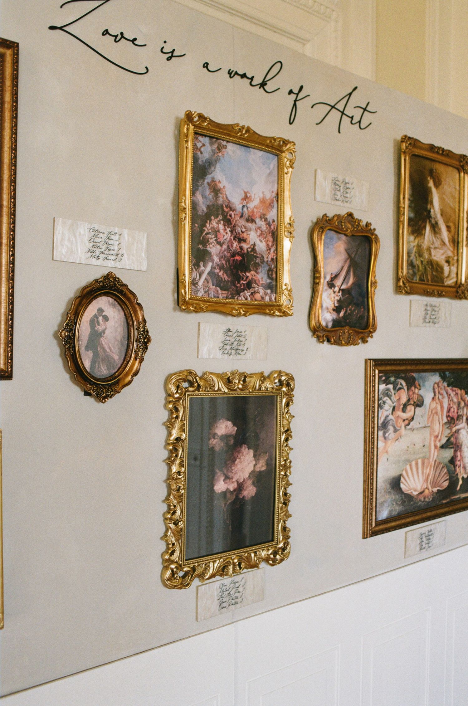 Gallery wall displaying ornate gold-framed paintings in a classic museum setting.